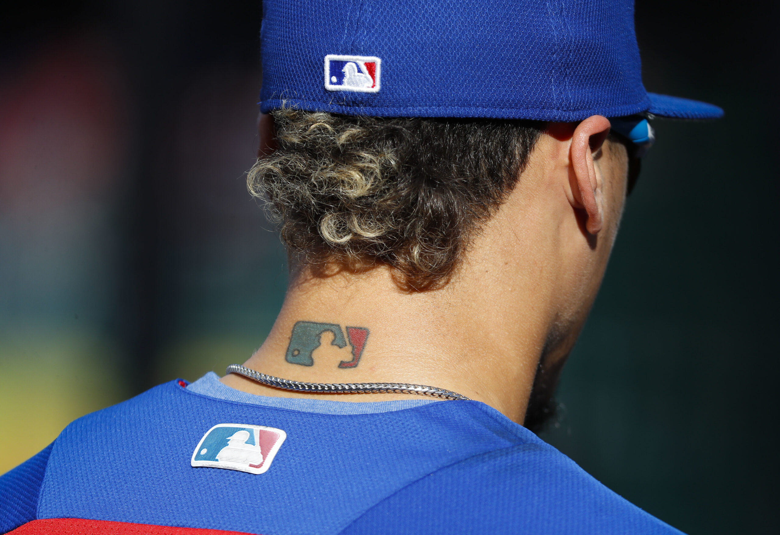 FILE - Then-Chicago Cubs' Javier Baez sports an MLB logo tattoo and logos on his hat and jersey as he waits to take batting practice before Game 2 of baseball's National League Division Series against the Washington Nationals at Nationals Park, Saturday, Oct. 7, 2017, in Washington. The clock ticked down toward the expiration of Major League Baseball’s collective bargaining agreement at 11:59 p.m. EST Wednesday night, Dec. 1, 2021, and what was likely to be a management lockout ending the sport’s labor peace at over 26 1/2 years. (AP Photo/Pablo Martinez Monsivais, File)