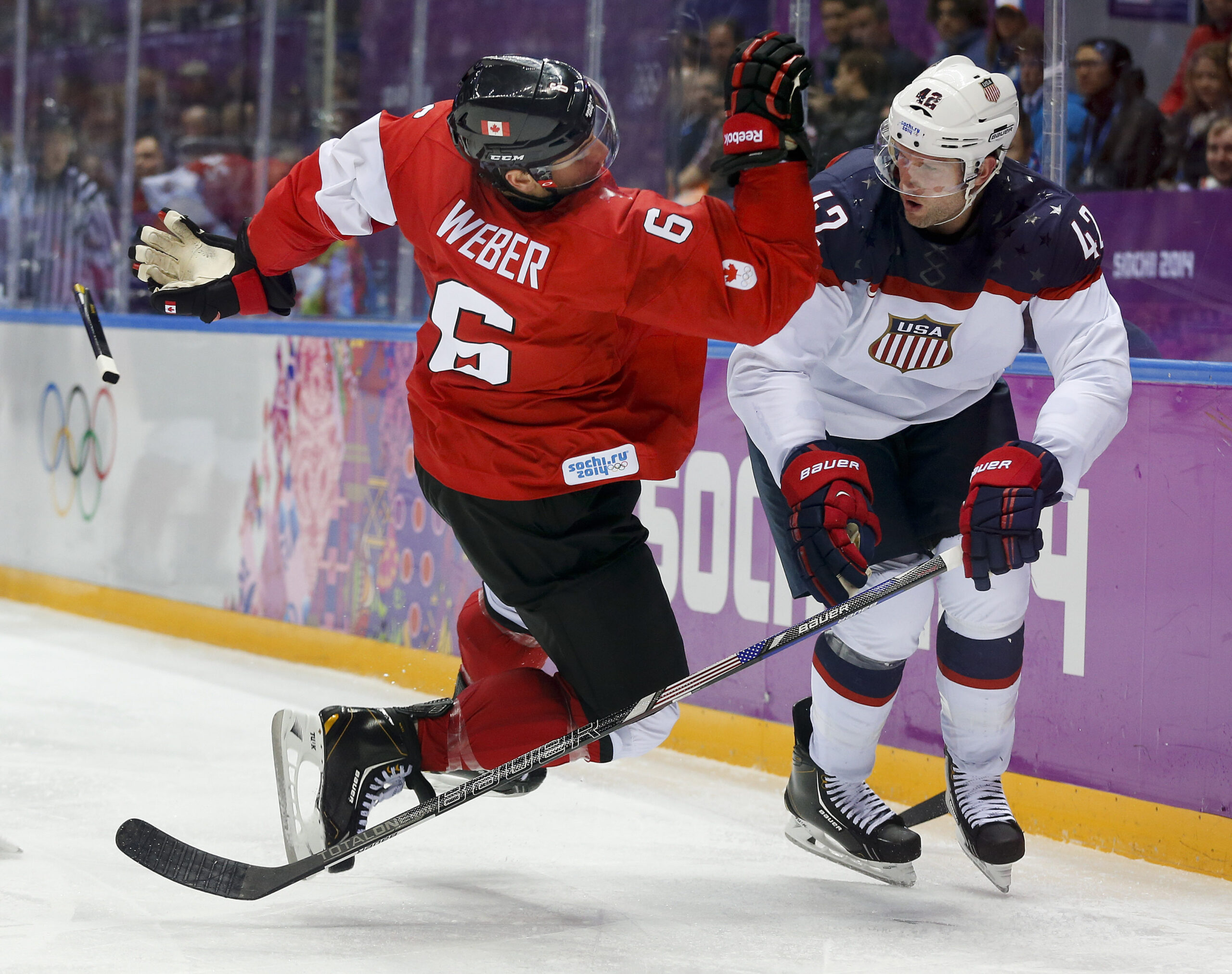 FILE -Canada defenseman Shea Weber, left, trips over USA forward David Backes during the third period of a men's semifinal ice hockey game at the 2014 Winter Olympics, Friday, Feb. 21, 2014, in Sochi, Russia. NHL players will not take part in the upcoming Winter Olympics in Beijing after all. A person with direct knowledge of the decision tells The Associated Press the league is going to withdraw from the Olympics after the regular-season schedule was disrupted by coronavirus outbreaks, Tuesday, Dec. 21, 2021.(AP Photo/Julio Cortez, File)