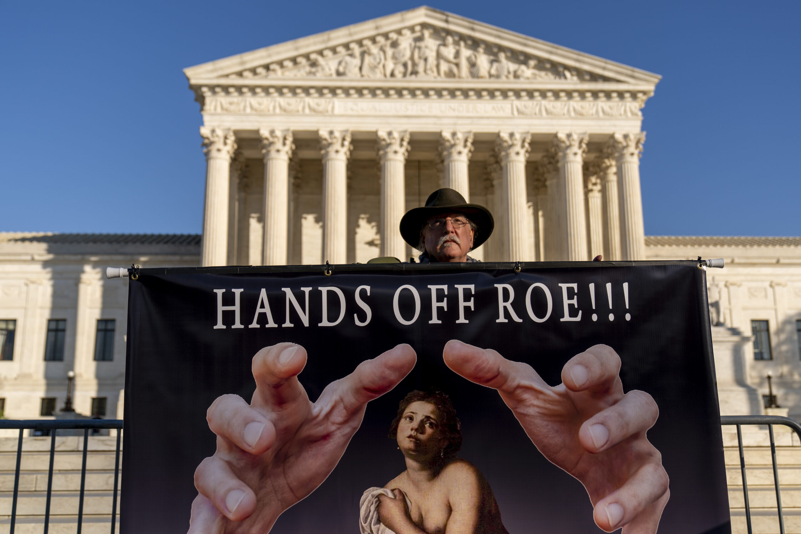 Stephen Parlato of Boulder, Colo., holds a sign that reads "Hands Off Roe!!!" outside of the Supreme Court in Washington, Tuesday, Nov. 30, 2021, as activists begin to arrive ahead of arguments on abortion at the court in Washington.(AP Photo/Andrew Harnik)