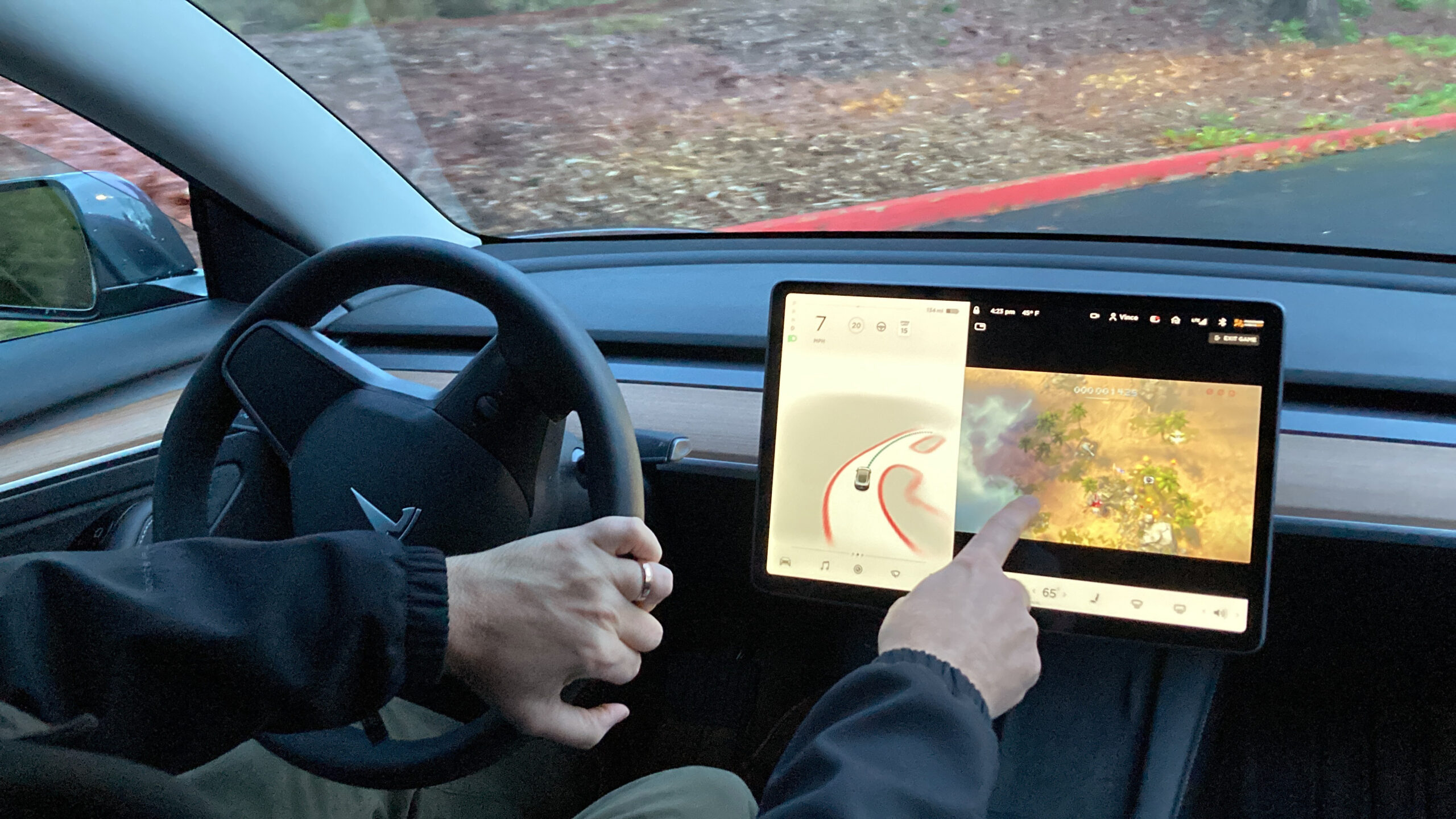 FILE - Vince Patton, a new Tesla owner, demonstrates on Dec. 8, 2021, on a closed course in Portland, Ore., how he can play video games on the vehicle's console while driving. The U.S. has opened a formal investigation into a report that Tesla vehicles allow people to play video games on a center touch screen while they are driving. (AP Photo/Gillian Flaccus, File)