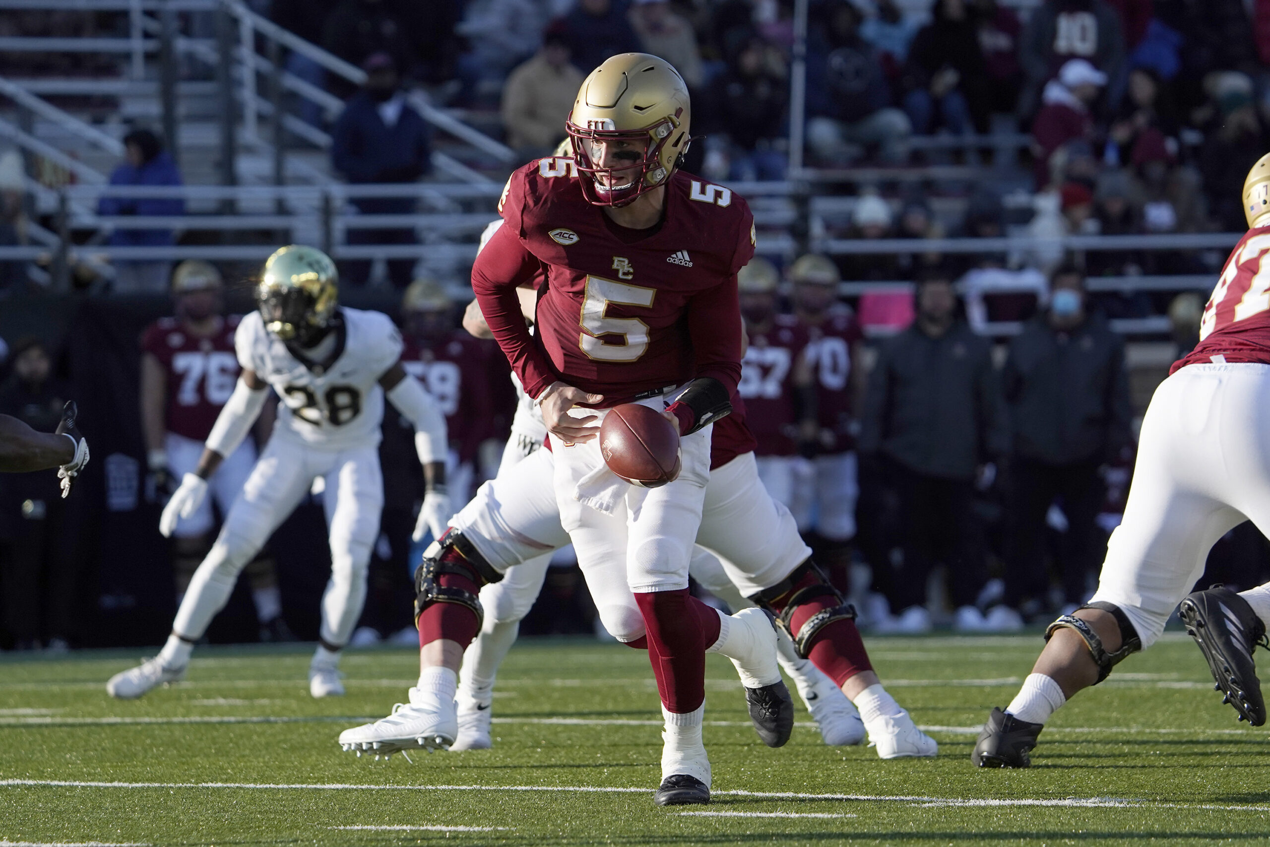 FILE - Boston College quarterback Phil Jurkovec (5) prepares to hand the ball off during the second half of an NCAA college football game against Wake Forest, Saturday, Nov. 27, 2021, in Boston. The Fenway Bowl and Military Bowl have been canceled due to the pandemic as coronavirus outbreaks at Virginia and Boston College forced them to call off their postseason plans. The Military Bowl scheduled for Monday, Dec. 27, at Navy-Marine Corps Memorial Stadium between Boston College and East Carolina was canceled because of positive COVID-19 tests at BC.(AP Photo/Mary Schwalm, File)