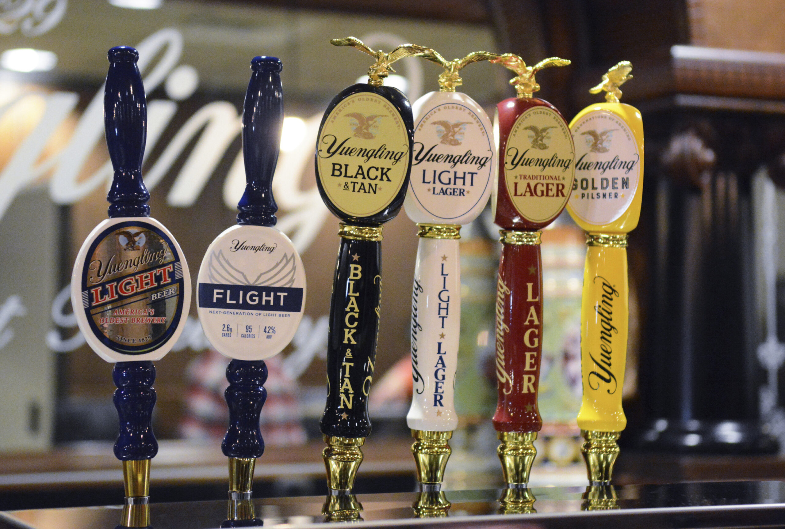FILE—In this Feb. 21, 2020 file photo, Yuengling's new upscale light beer, Flight, is seen on tap with Yuengling's other beers at D.G. Yuengling & Son's Mill Creek brewery in Pottsville, Pa. A trademark tiff between America’s oldest beer maker and its best-selling beer brand appears to be over before it really began. Last week, D.G. Yuengling & Son demanded its much larger rival, Anheuser-Busch, stop using a tagline for its forthcoming Bud Light Next zero-carb beer. Bud Light had been calling it the “next generation of beer.” Yuengling says that's too close to the trademarked slogan it uses for its Flight low-carb brew. (Lindsey Shuey/Republican-Herald via AP, File)