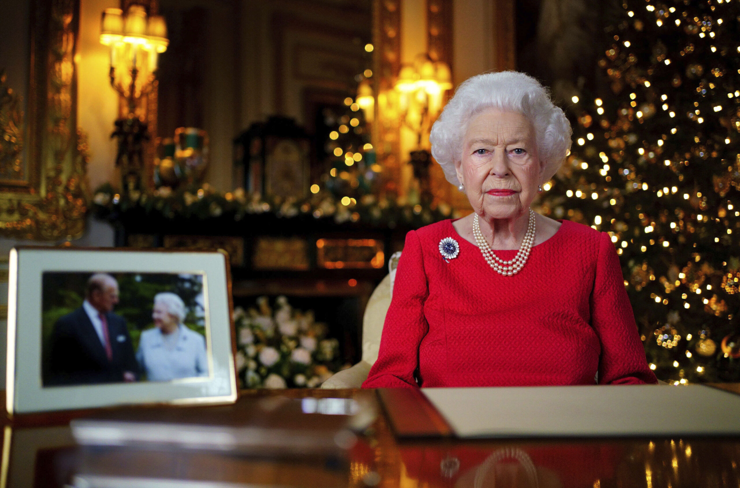 FILE - In this undated photo issued on Dec. 23, 2021, Britain's Queen Elizabeth II records her annual Christmas broadcast in Windsor Castle, Windsor, England. The United Kingdom will celebrate Queen Elizabeth II’s 70 years on the throne with a military parade, neighborhood parties and a competition to create a new dessert for the Platinum Jubilee, Buckingham Palace said Monday, Jan. 10, 2022. (Victoria Jones/Pool Photo via AP, File)