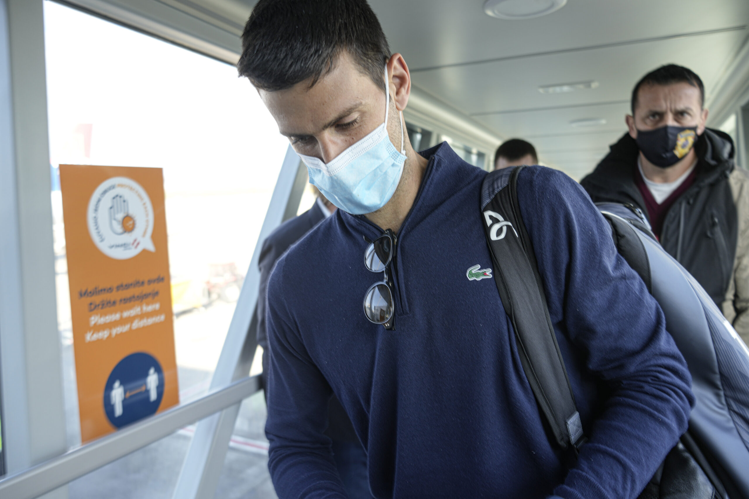 Novak Djokovic looks as his documents after landing in Belgrade, Serbia, Monday, Jan. 17, 2022. Djokovic arrived in the Serbian capital following his deportation from Australia on Sunday after losing a bid to stay in the country to defend his Australian Open title despite not being vaccinated against COVID-19.(AP Photo/Darko Bandic)