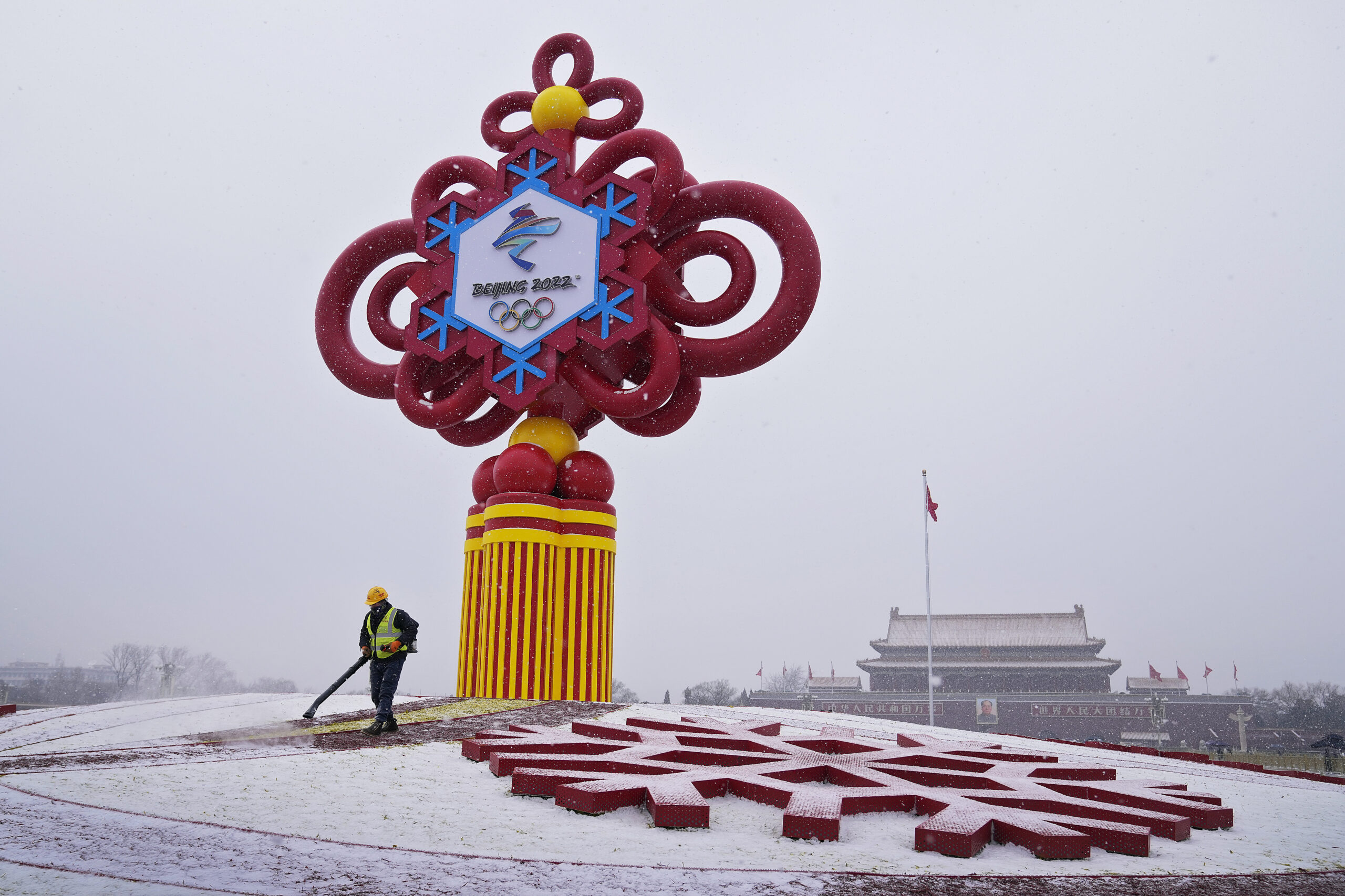 FILE - A worker wearing a face mask to protect from the coronavirus uses a blower to clean the snow on a decoration for the Beijing Winter Olympics Games on display at Tiananmen Square in Beijing, Jan. 20, 2022. The U.S. Olympic team's top doctor says all of the 200-plus athletes heading to Beijing for the Winter Games next month are fully vaccinated, and not a single one asked for a medical exemption. (AP Photo/Andy Wong, File)