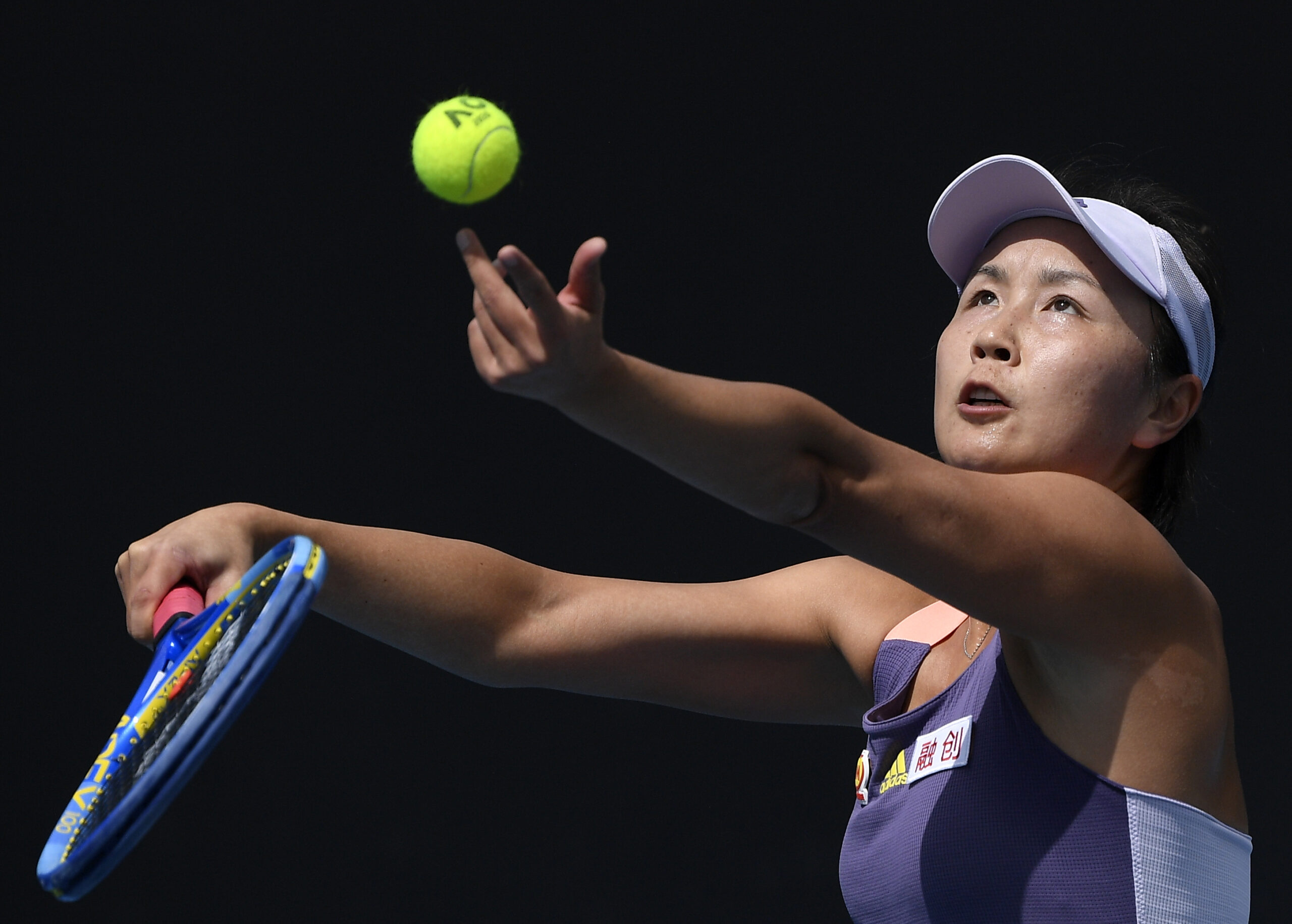 FILE - China's Peng Shuai serves to Japan's Nao Hibino during their first round singles match at the Australian Open tennis championship in Melbourne, Australia, on Jan. 21, 2020. The whereabout of Peng remains a pressing question at the Beijing Olympics. Peng’s accusations of sexual assault months ago against former vice premier Zhang Gaoli, once a member of the all-powerful Politburo Standing Committee, were scrubbed almost immediately from the internet in China. (AP Photo/Andy Brownbill, File)