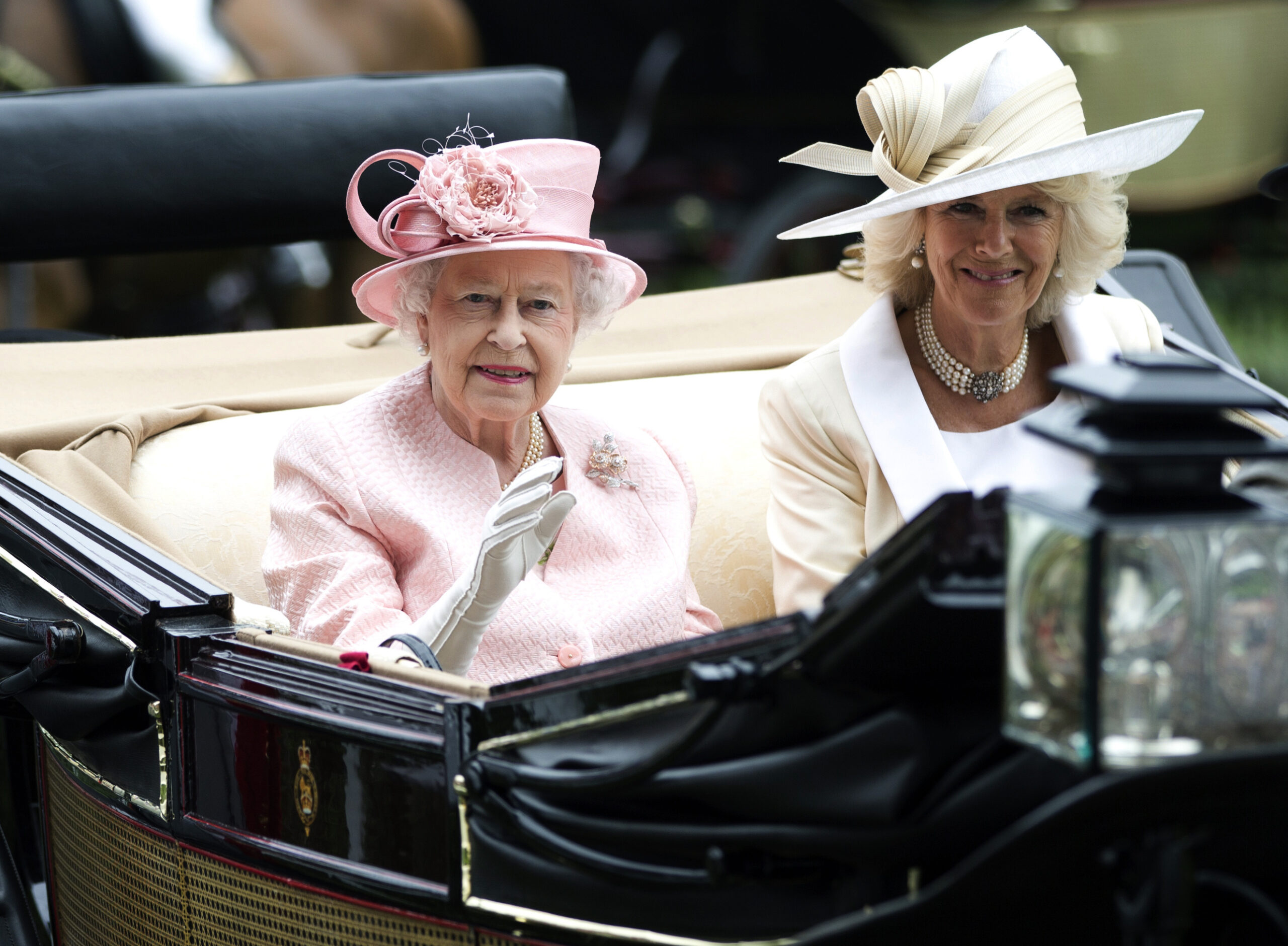 FILE - Britain's Queen Elizabeth II waves to the crowds with Camilla, Duchess of Cornwall at right, as they arrive by carriage on the first day of the Royal Ascot horse race meeting in Ascot, England, Tuesday, June 18, 2013. Queen Elizabeth II has offered her support to have the Duchess of Cornwall become Queen Camilla — using a special Platinum Jubilee message to make a significant decision in shaping the future of the monarchy. (AP Photo/Alastair Grant, File)