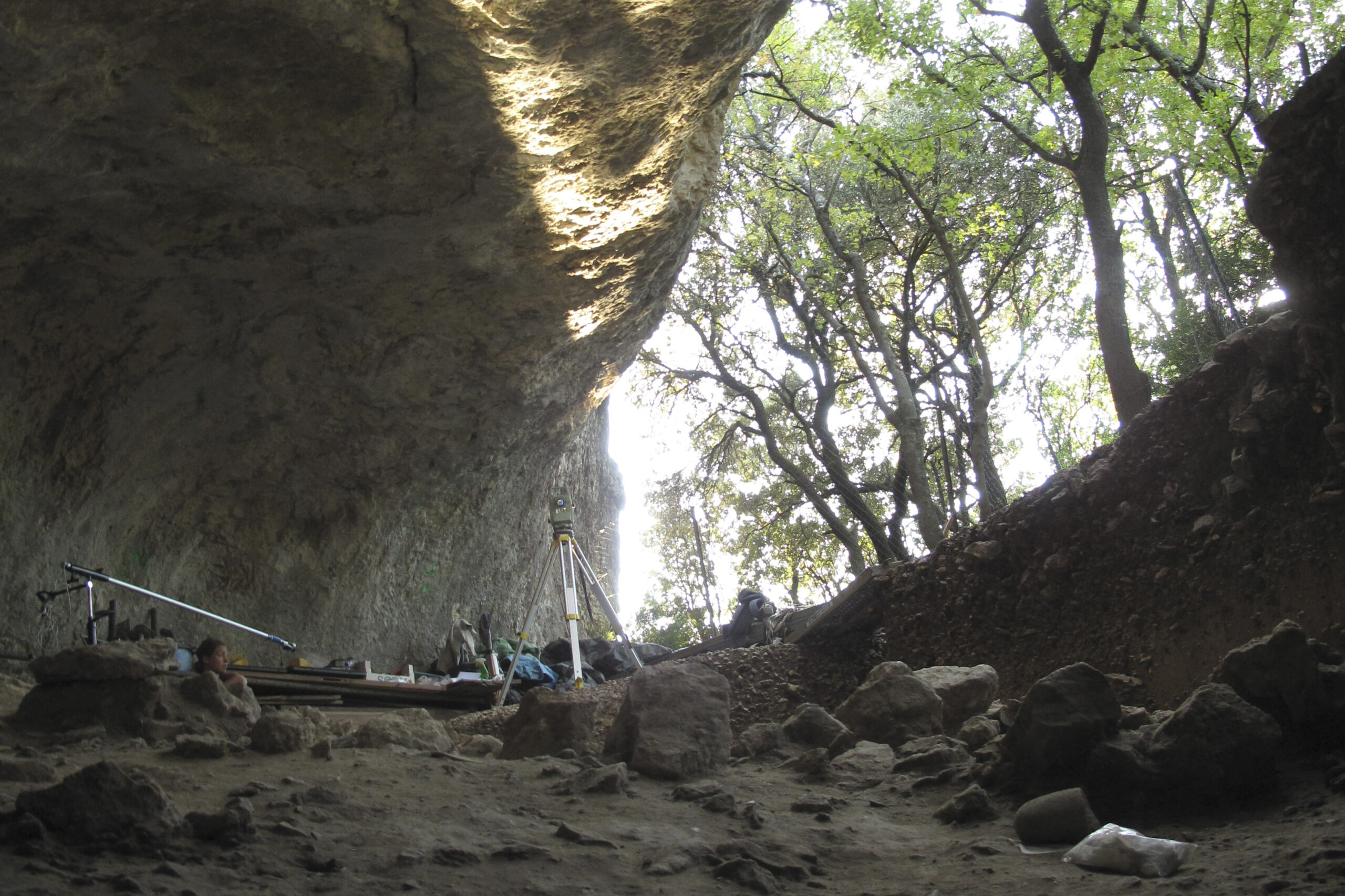 This undated photo provided by Ludovic Slimak shows scientists working at the entrance of the Mandrin cave, near Montelimar, southern France. Scientists have uncovered fossilized modern human remains and tools sandwiched between Neanderthal remains and tools in the stratigraphic record at a site in the Rhône Valley in France, suggesting occupation of the area alternated between Neanderthals and modern humans. (Ludovic Slimak via AP)