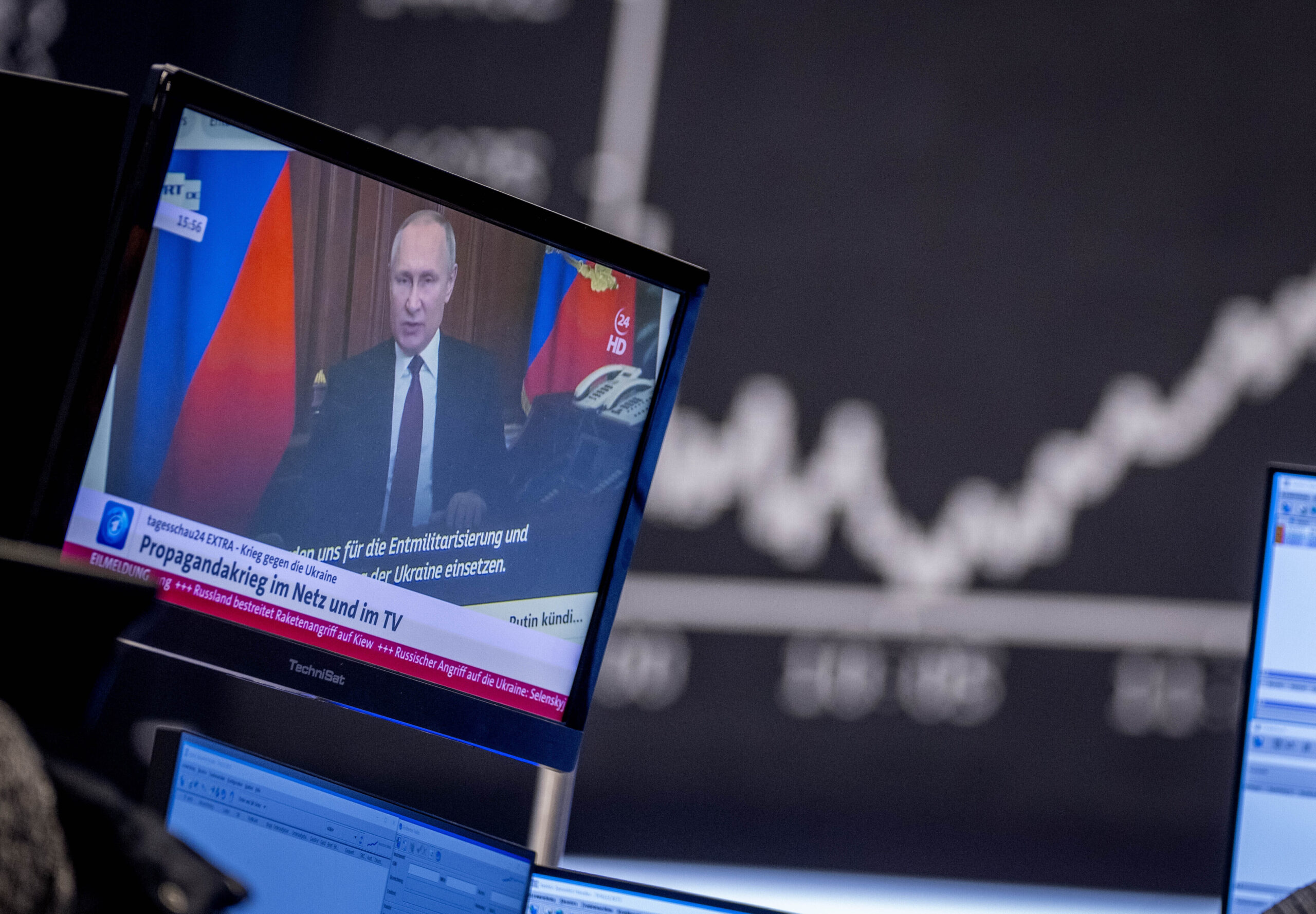 FILE - Russia's President Vladimir Putin appears on a television screen at the stock market in Frankfurt, Germany, Feb. 25, 2022. Russia is revving up its sophisticated propaganda machine as its military advances in neighboring Ukraine. Analysts who monitor propaganda and disinformation say they've seen a sharp increase in online activity linked to the Russian state in recent weeks. (AP Photo/Michael Probst, File)