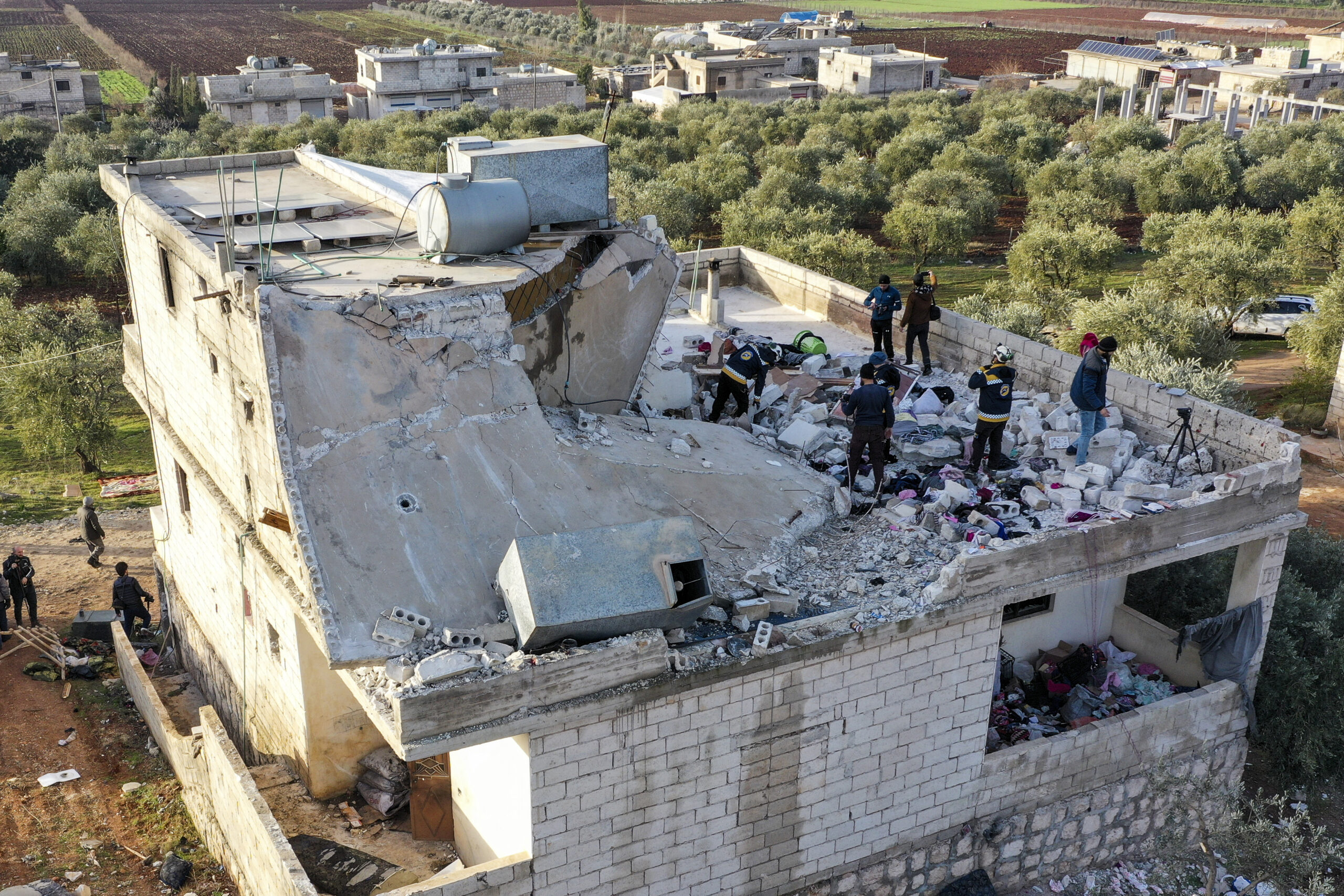 People inspect a destroyed house following an operation by the U.S. military in the Syrian village of Atmeh, in Idlib province, Syria, Thursday, Feb. 3, 2022. U.S. special operations forces conducted a large-scale counterterrorism raid in northwestern Syria overnight Thursday, in what the Pentagon said was a "successful mission." Residents and activists reported multiple deaths including civilians from the attack. (AP Photo/Ghaith Alsayed)