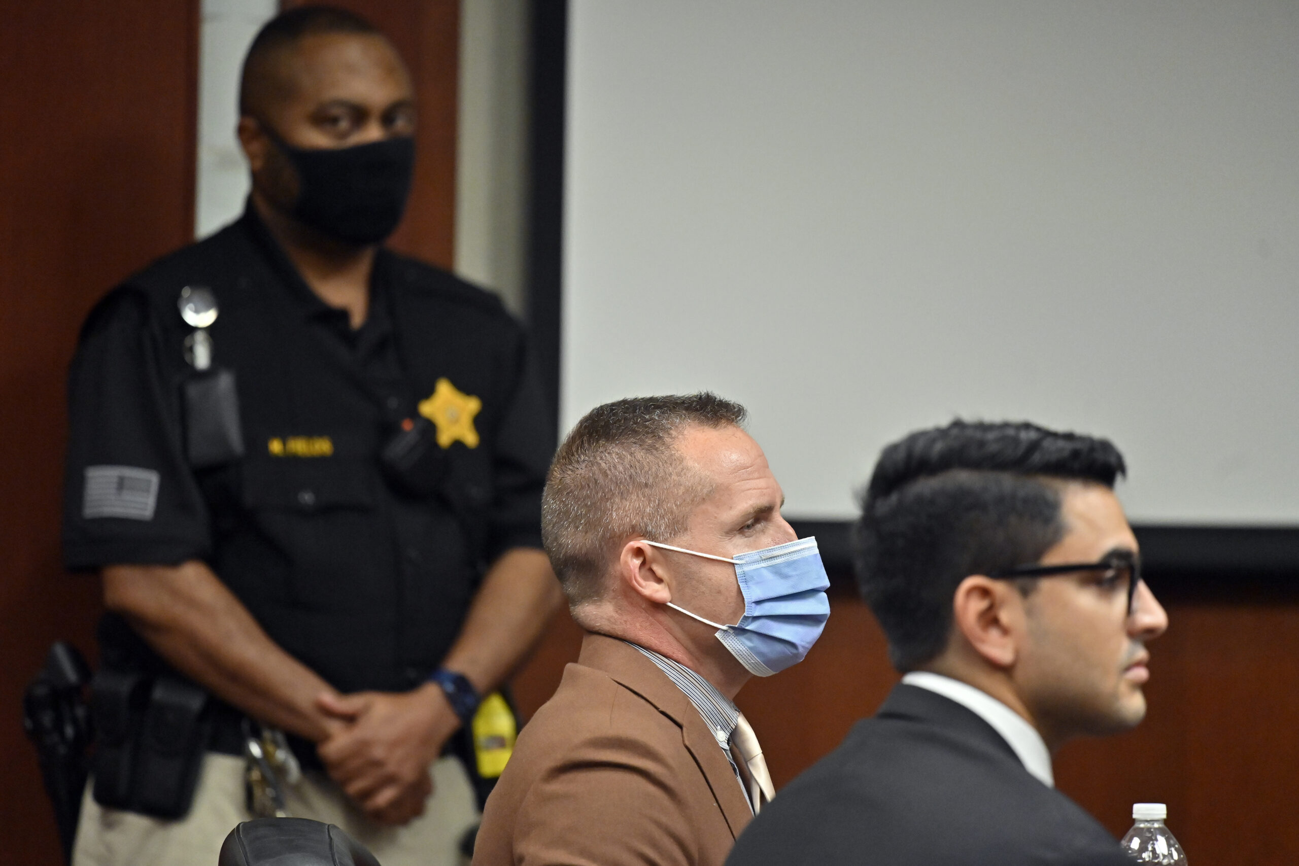 Former Louisville Police Officer Brett Hankison, center, awaits the jury's verdict in his wanton endangerment trial, Thursday, March 3, 2022, in Louisville, Ky. The jury cleared Hankison of charges that he endangered neighbors when he fired shots into an apartment during the 2020 drug raid that ended with Breonna Taylor’s death. (AP Photo/Timothy D. Easley, Pool)