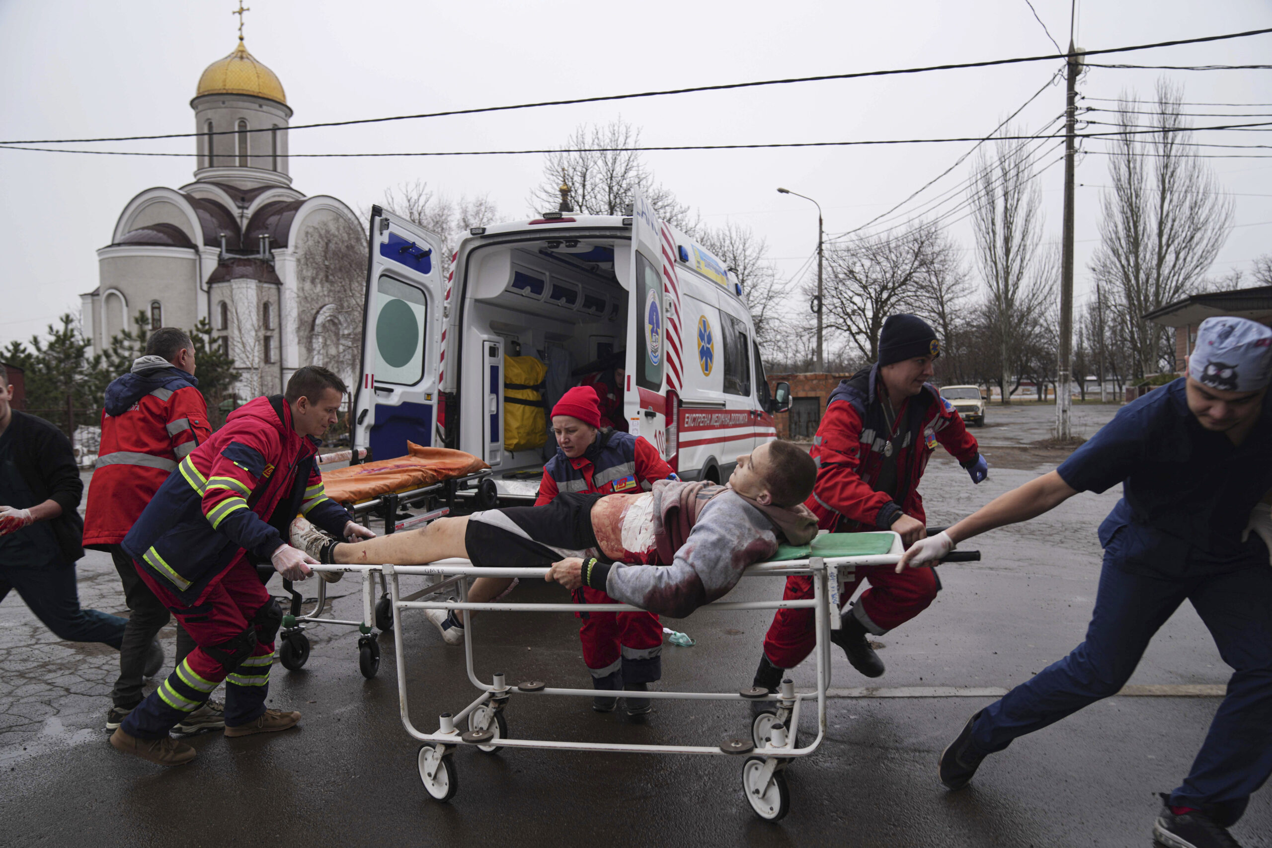 Ambulance paramedics move an injured man on a stretcher, wounded by shelling in a residential area, at the maternity hospital converted into a medical ward and used as a bomb shelter in Mariupol, Ukraine, Tuesday, March 1, 2022. Russian strikes on the key southern port city of Mariupol seriously wounded several people. (AP Photo/Evgeniy Maloletka)
