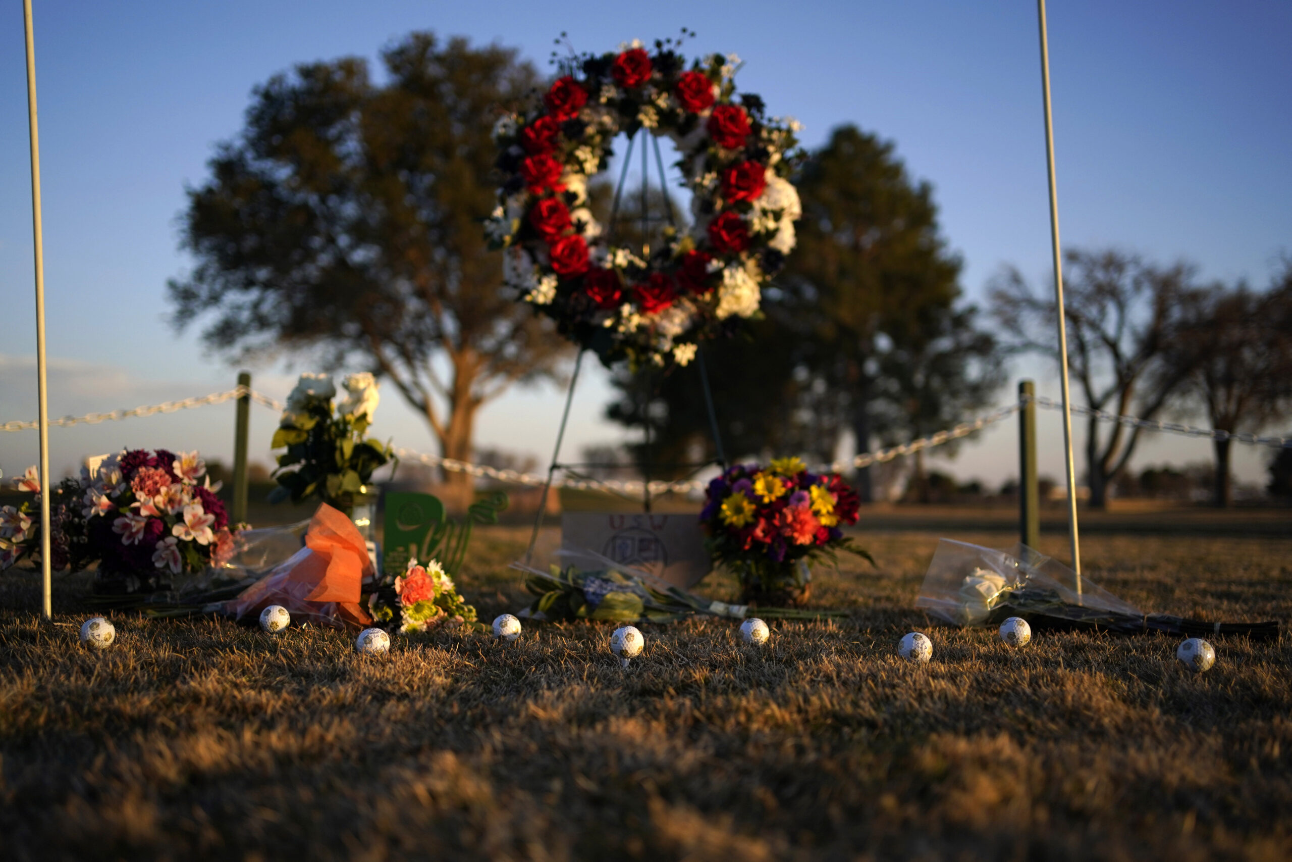 Golf balls adorn a makeshift memorial at the Rockwind Community Links, Wednesday, March 16, 2022, in Hobbs, New Mexico. The memorial was for student golfers and the coach of University of the Southwest killed in a crash in Texas. (AP Photo/John Locher)