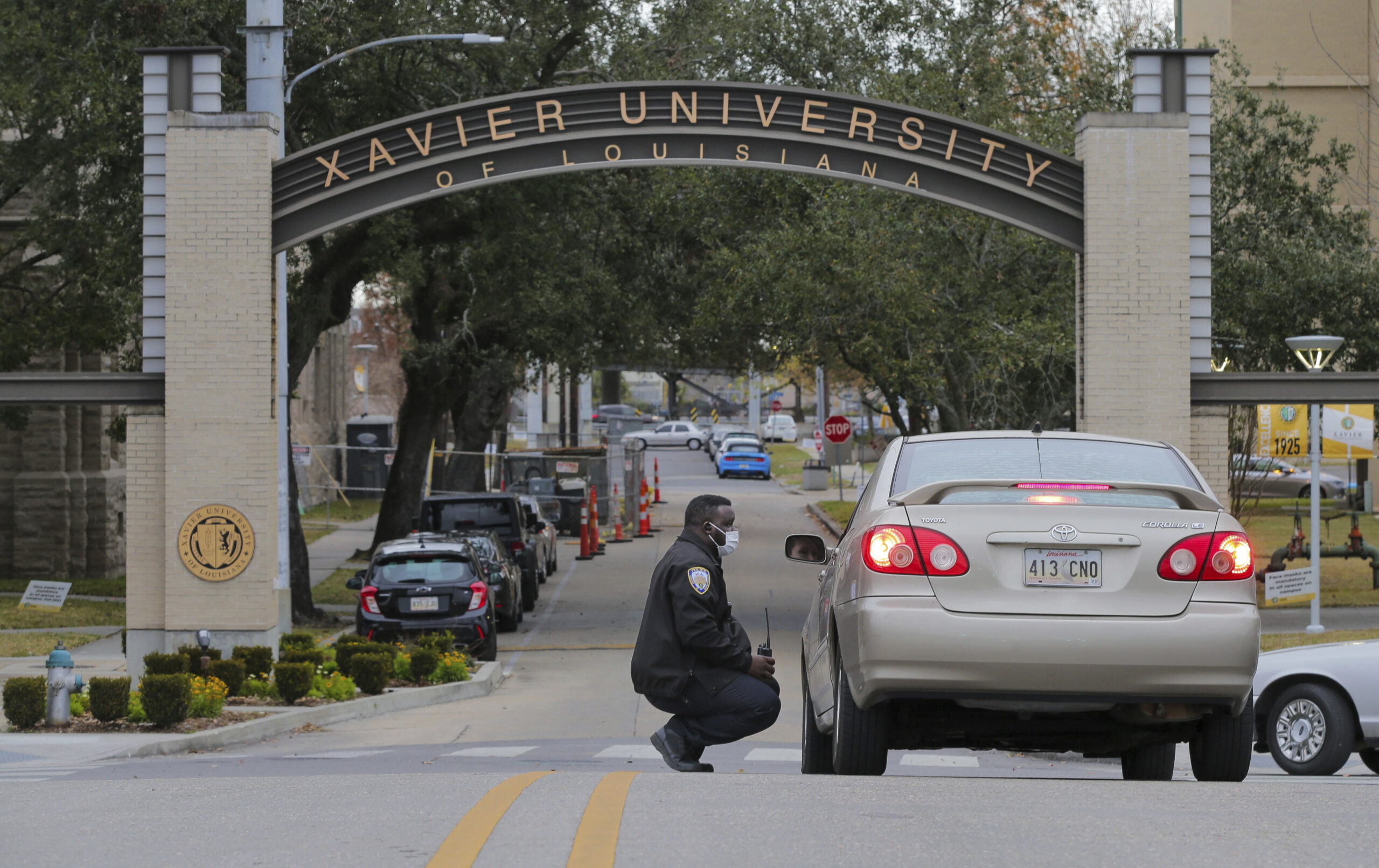 FILE - A Xavier University police officer redirects a motorist around campus after a bomb threat put the campus on lockdown in New Orleans, La., Feb. 1, 2022. As the nation’s historically Black colleges remain on edge after receiving dozens of bomb threats in recent weeks, federal law enforcement officials said they have identified six suspects who they believe are responsible for most of the racially motivated crimes. (David Grunfeld/The Advocate via AP, File)