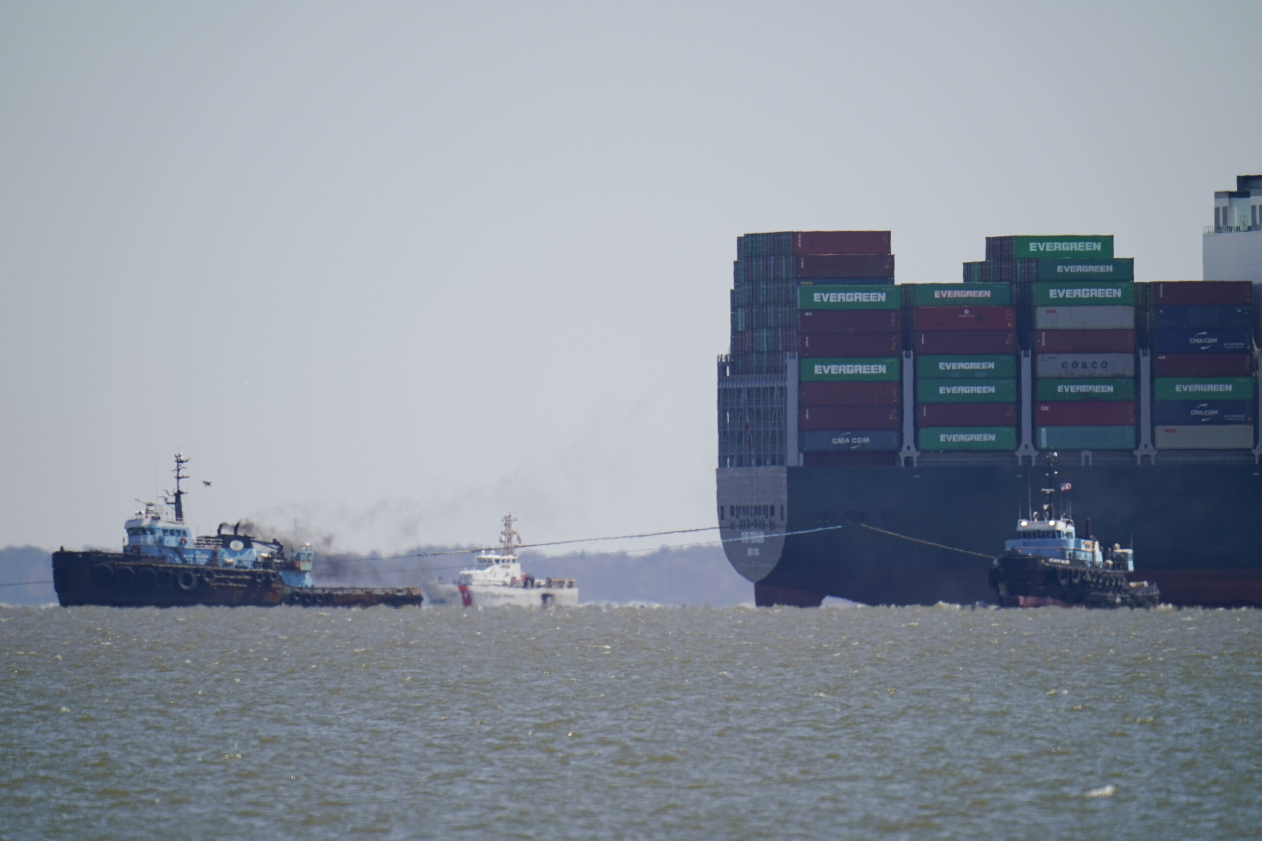 The tugboats Atlantic Enterprise, left, and Atlantic Salvor, bottom right, use lines to pull the container ship Ever Forward, top right, which ran aground in the Chesapeake Bay, as crews began to attempt to refloat the ship, Tuesday, March 29, 2022, in Pasadena, Md. (AP Photo/Julio Cortez)