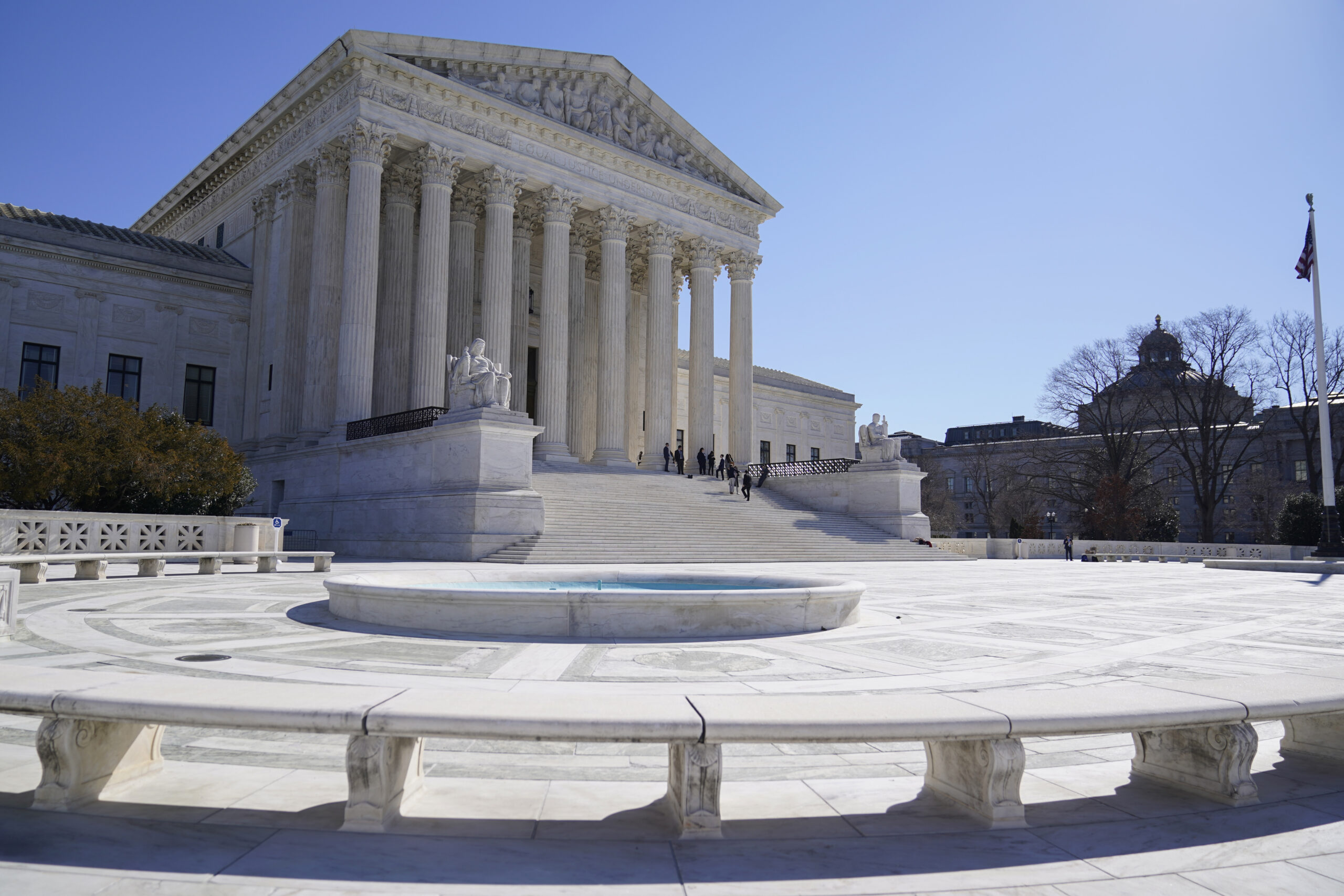 FILE - People stand on the steps of the U.S. Supreme Court, Feb.11, 2022, in Washington. (AP Photo/Mariam Zuhaib, File)