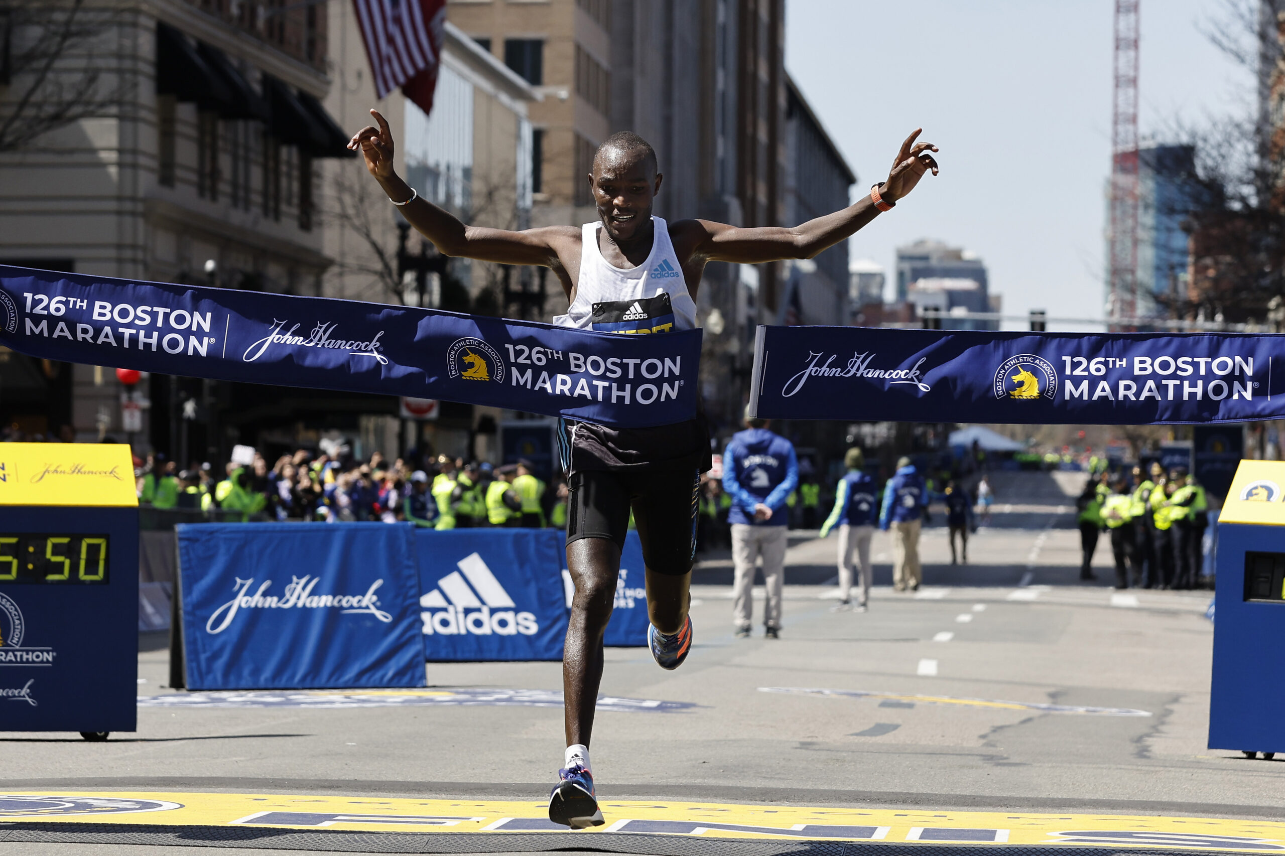 Evans Chebet, of Kenya, hits the tape to win the 126th Boston Marathon, Monday, April 18, 2022, in Boston. (AP Photo/Winslow Townson)