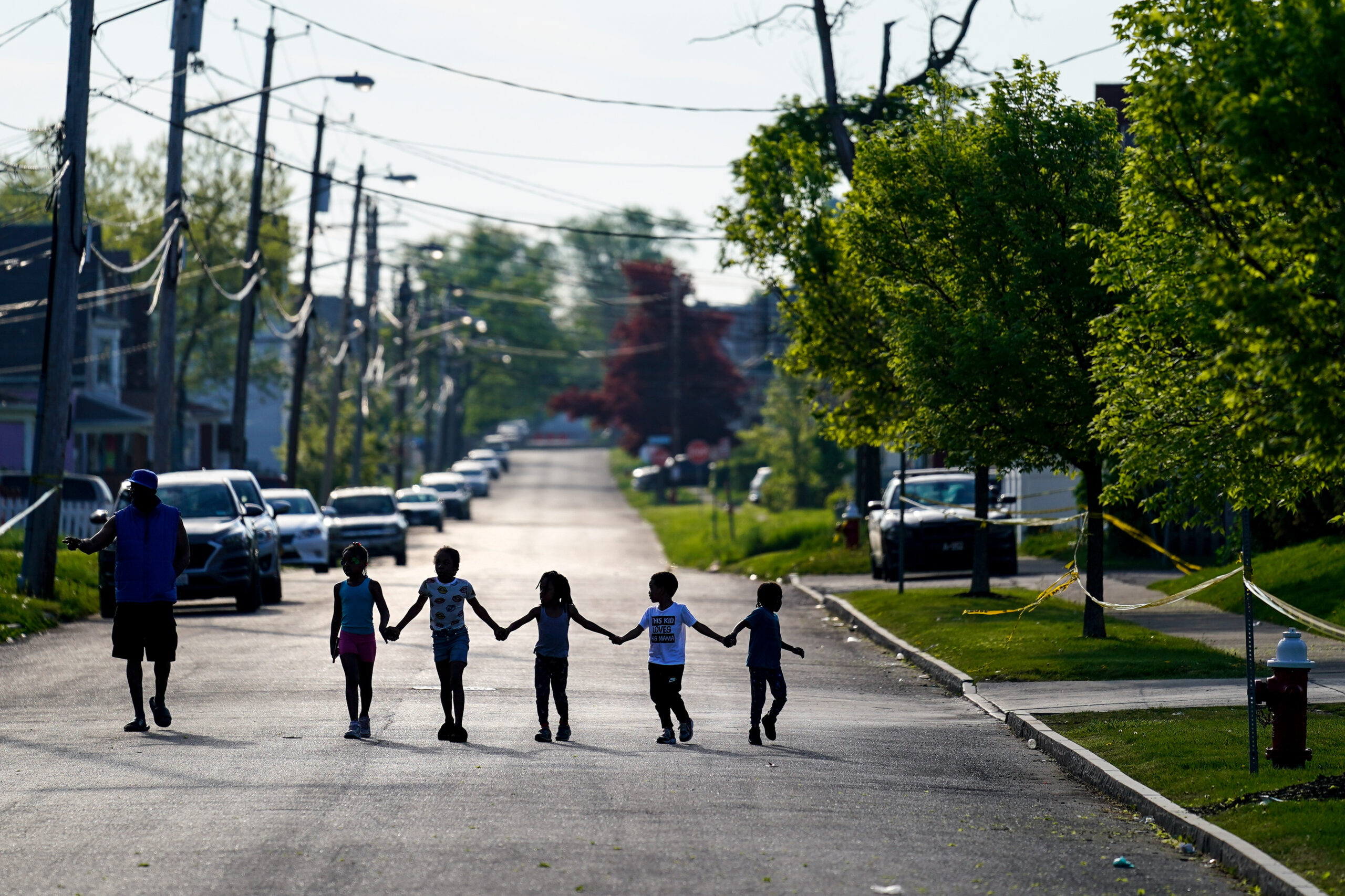 Children walk hand in hand out near the scene of a shooting at a supermarket in Buffalo, N.Y., Sunday, May 15, 2022. (AP Photo/Matt Rourke)
