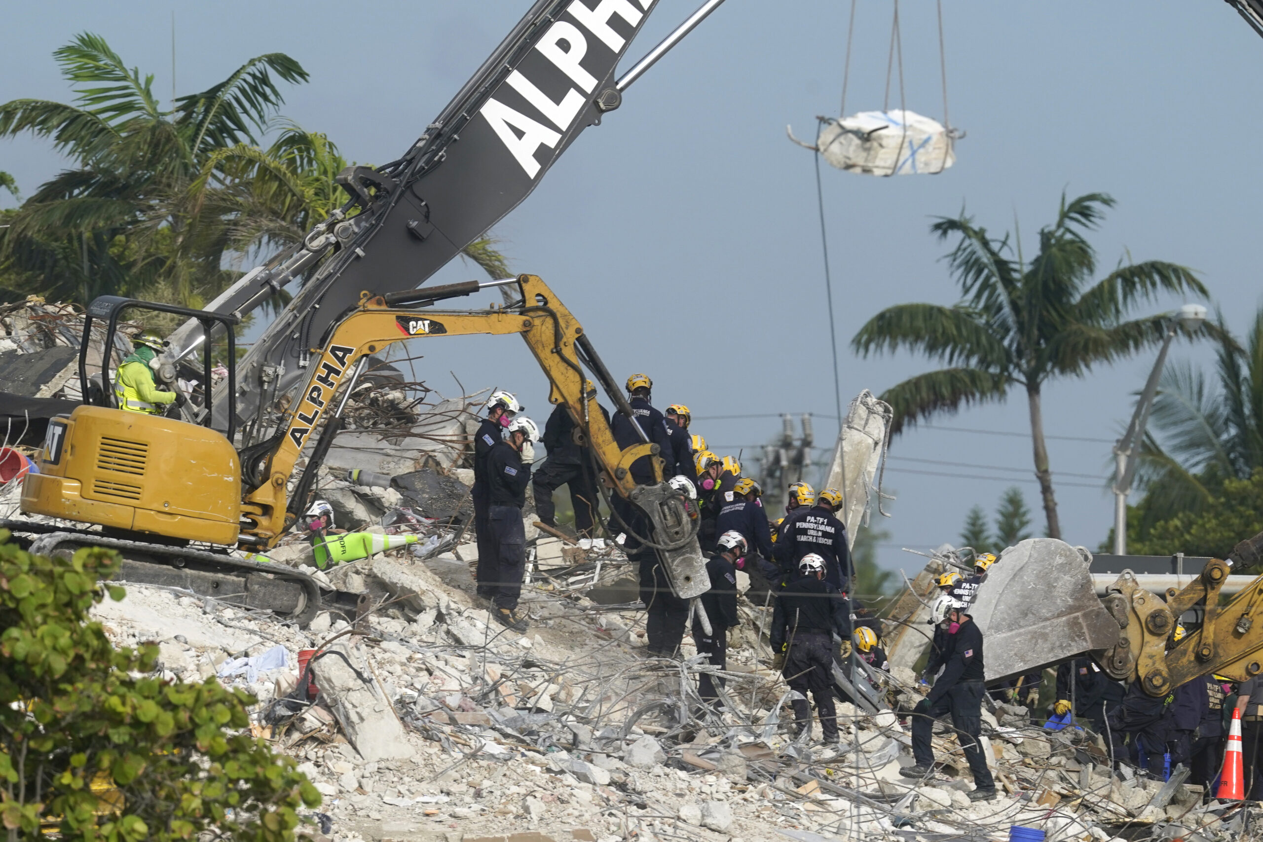 FILE - Rescue crews work at the site of the collapsed Champlain Towers South condo building after the remaining structure was demolished Sunday, in Surfside, Fla., Monday, July 5, 2021. Attorneys for the families who lost relatives or homes in last year’s collapse of a Florida condominium tower that killed 98 people finalized a $1 billion settlement on Friday, May 27, 2022. (AP Photo/Lynne Sladky, File)