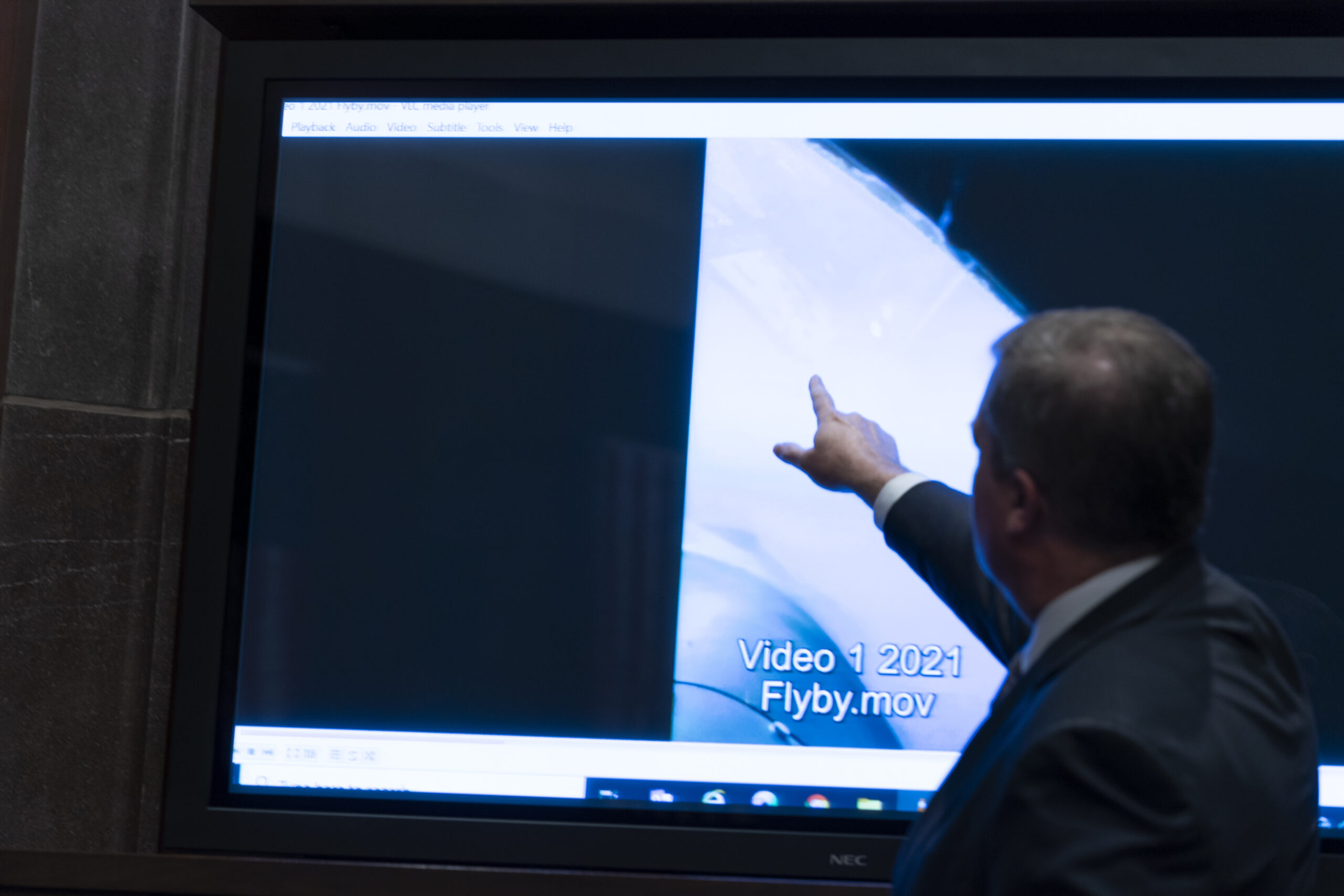 Deputy Director of Naval Intelligence Scott Bray points to a video display of a UAP during a hearing of the House Intelligence, Counterterrorism, Counterintelligence, and Counterproliferation Subcommittee hearing on "Unidentified Aerial Phenomena," on Capitol Hill, Tuesday, May 17, 2022, in Washington. (AP Photo/Alex Brandon)