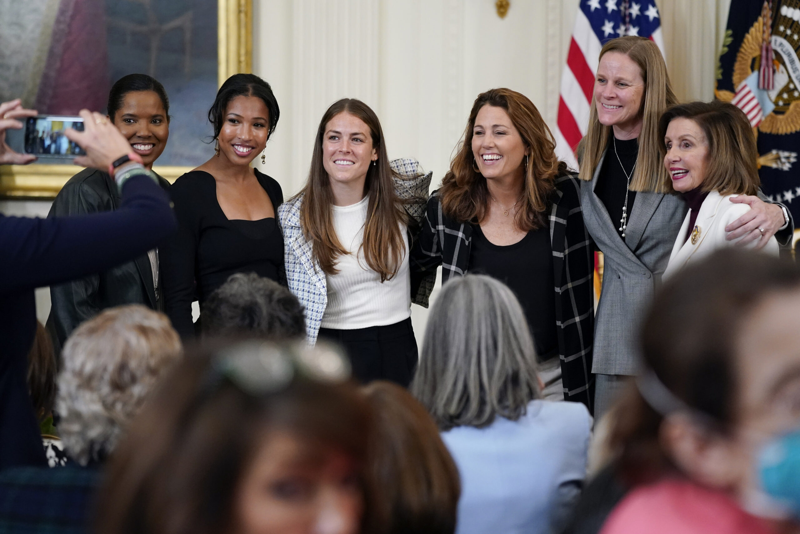 FILE - Former members and members of the U.S. Women's National soccer team, from left, Briana Scurry, Margaret 'Midge' Purce, Kelley O'Hara, Julie Foudy, and Cindy Parlow Cone, President of U.S. Soccer, pose for a photo with House Speaker Nancy Pelosi of Calif., before an event to celebrate Equal Pay Day and Women's History Month in the East Room of the White House, Tuesday, March 15, 2022, in Washington. The U.S. Soccer Federation reached milestone agreements to pay its men's and women's teams equally, making the American national governing body the first in the sport to promise both sexes matching money. (AP Photo/Patrick Semansky, File)