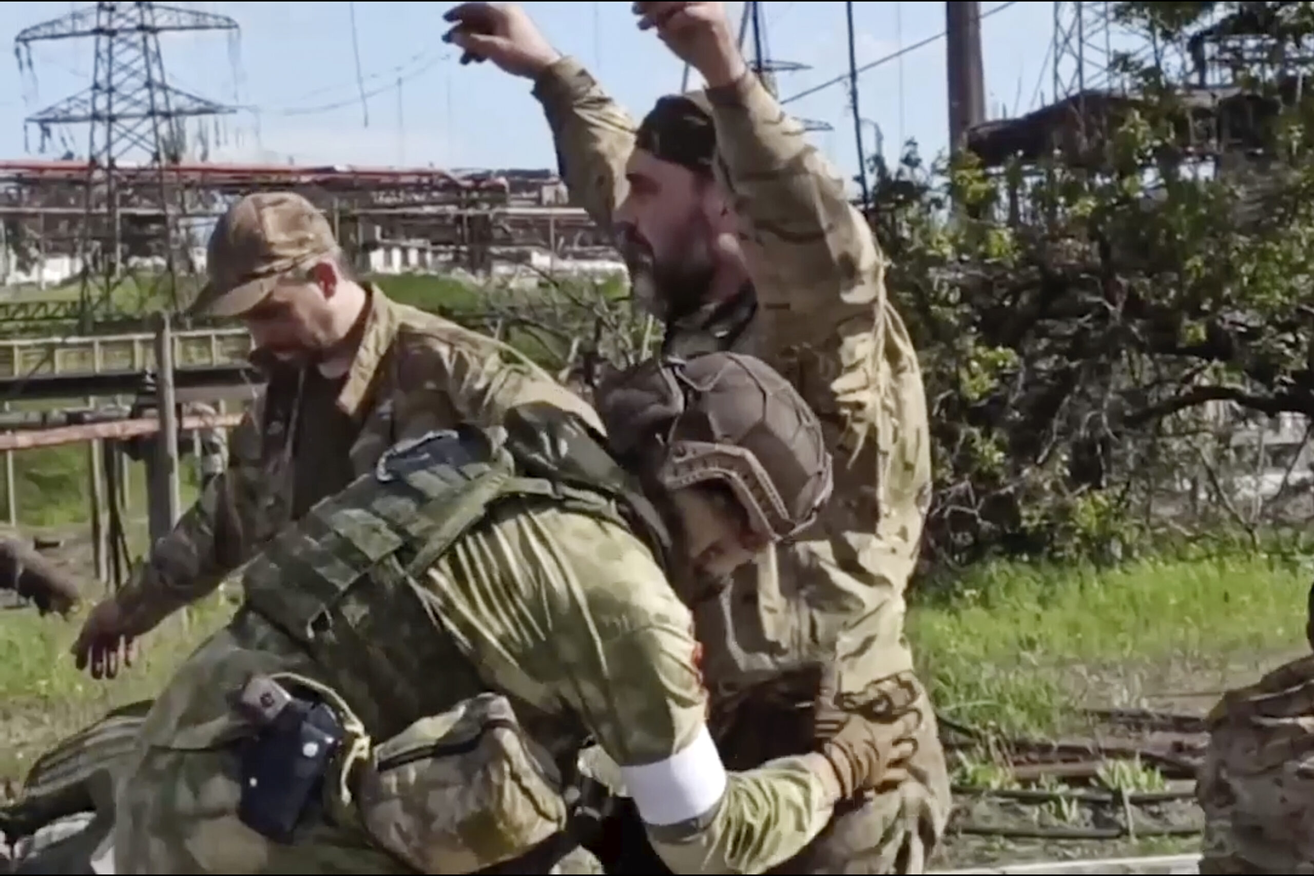 In this photo taken from video released by the Russian Defense Ministry Press Service on Tuesday, May 17, 2022, shows Russian servicemen frisk Ukrainian servicemen as they are being evacuated from the besieged Azovstal steel plant in Mariupol, Ukraine. More than 260 fighters, some severely wounded, were pulled from a steel plant on Monday that is the last redoubt of Ukrainian fighters in the city and transported to two towns controlled by separatists, officials on both sides said. (Russian Defense Ministry Press Service via AP)