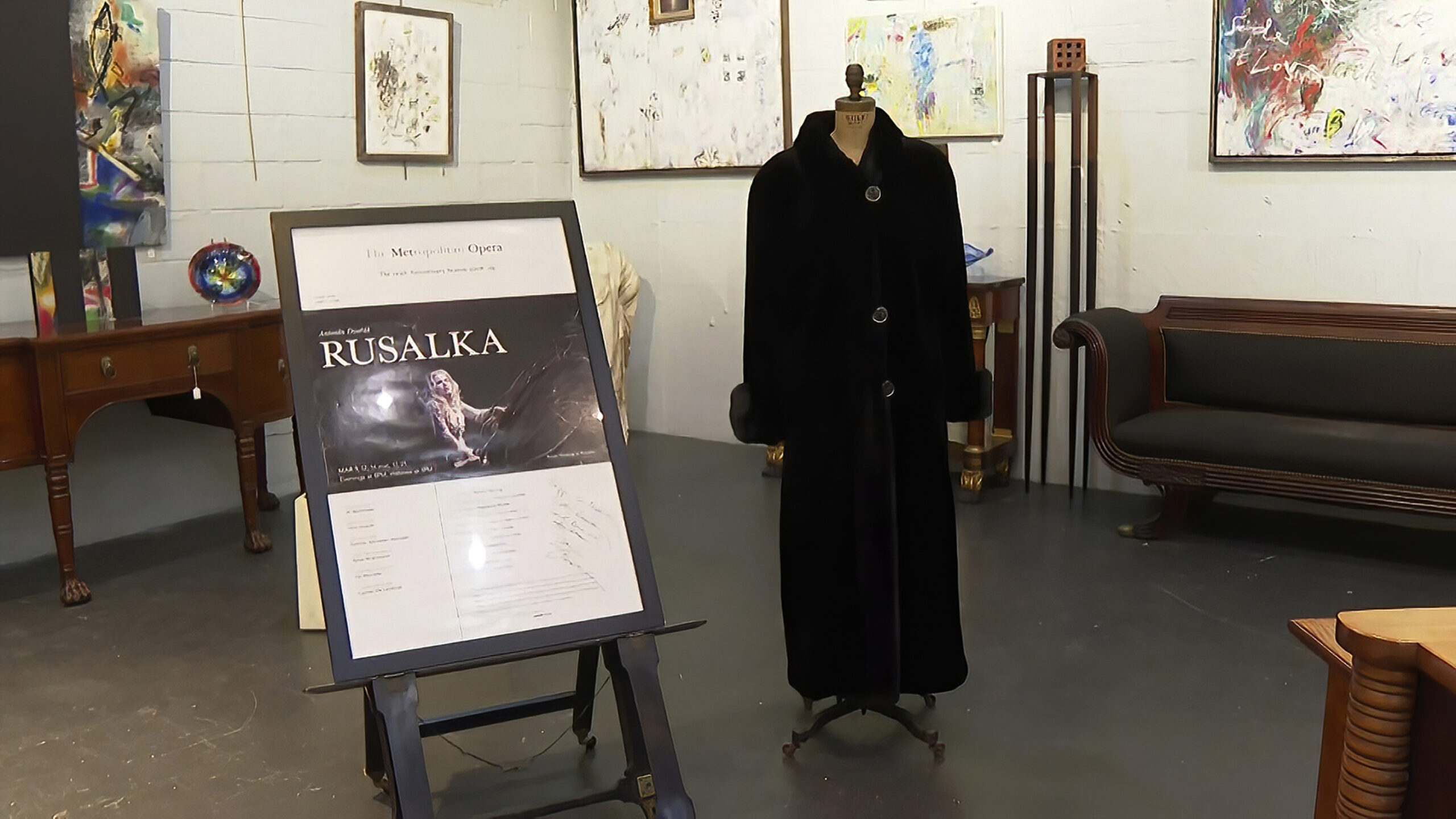 FILE - In this image from video, a black mink fur coat, right, and a signed opera poster belonging to the late Justice Ruth Bader Ginsburg, are seen inside Potomack Company Auctions in Alexandria, Va., Monday, April 11, 2022. An online auction of 150 of items owned by Ginsburg raised $803,650 for Washington National Opera. The opera was one of the late justice’s passions. (AP Photo/Nathan Ellgren, File)