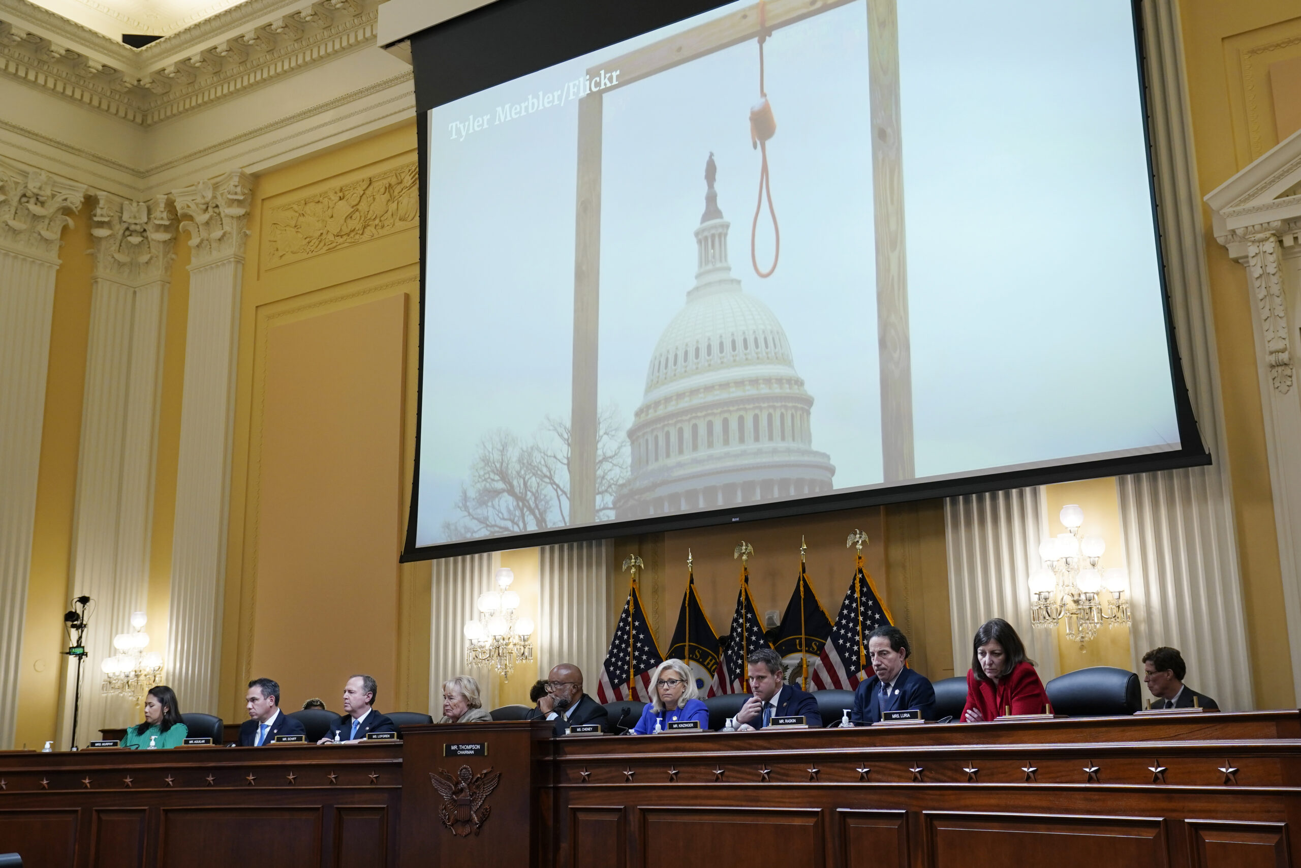 An image of a mock gallows on the grounds of the U.S. Capitol on Jan. 6th is shown as committee members from left to right, Rep. Stephanie Murphy, D-Fla., Rep. Pete Aguilar, D-Calif., Rep. Adam Schiff, D-Calif., Rep. Zoe Lofgren, D-Calif., Chairman Bennie Thompson, D-Miss., Vice Chair Liz Cheney, R-Wyo., Rep. Adam Kinzinger, R-Ill., Rep. Jamie Raskin, D-Md., and Rep. Elaine Luria, D-Va., look on, as the House select committee investigating the Jan. 6 attack on the U.S. Capitol holds its first public hearing to reveal the findings of a year-long investigation, at the Capitol in Washington, Thursday, June 9, 2022. (AP Photo/J. Scott Applewhite)