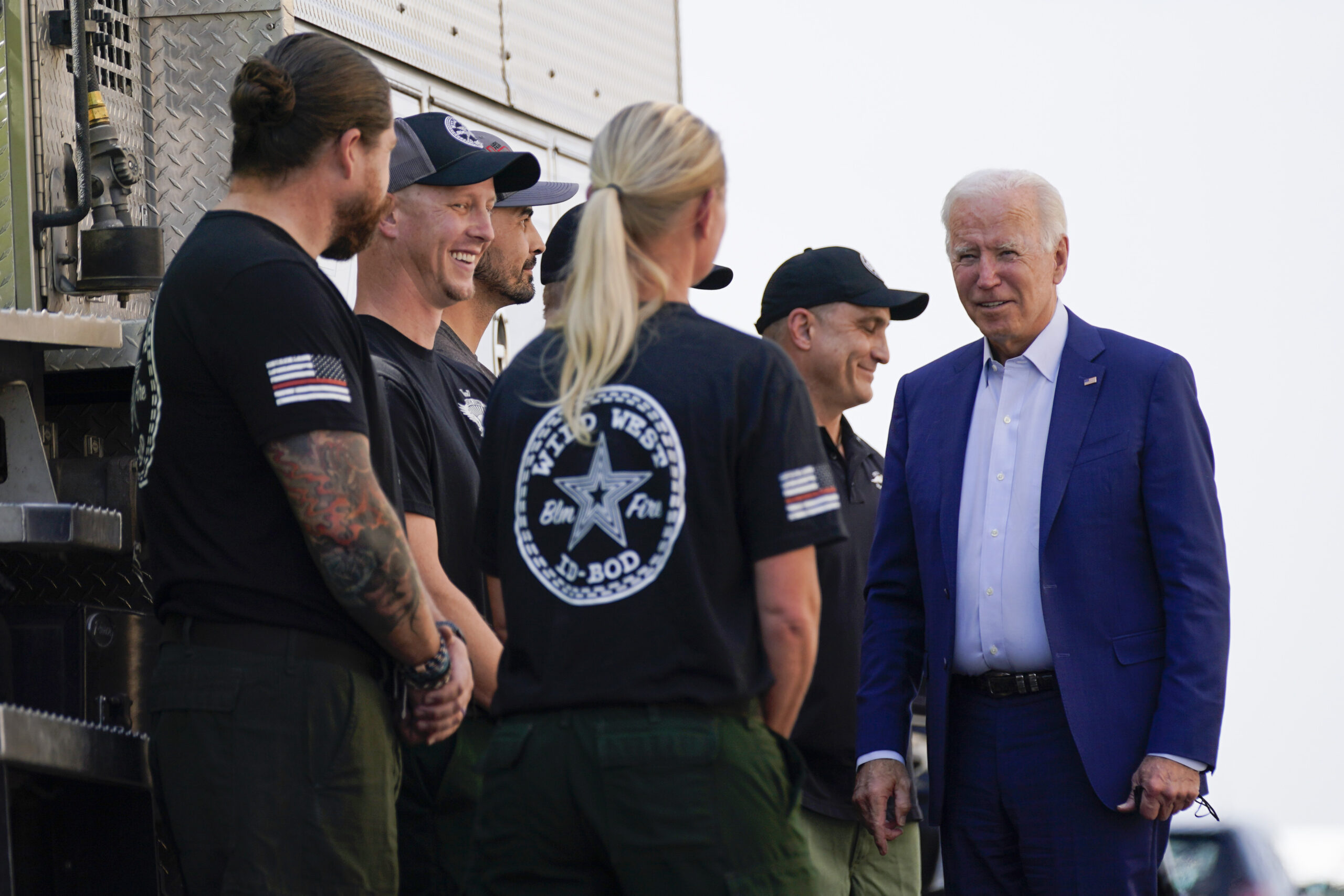 FILE - President Joe Biden greets firefighters as he tours the National Interagency Fire Center, Sept. 13, 2021, in Boise, Idaho. Biden on June 21, 2022, signed off on giving federal wildland firefighters a hefty raise for the next two fiscal years, a move that comes as much of the West is bracing for a difficult wildfire season. (AP Photo/Evan Vucci, File)