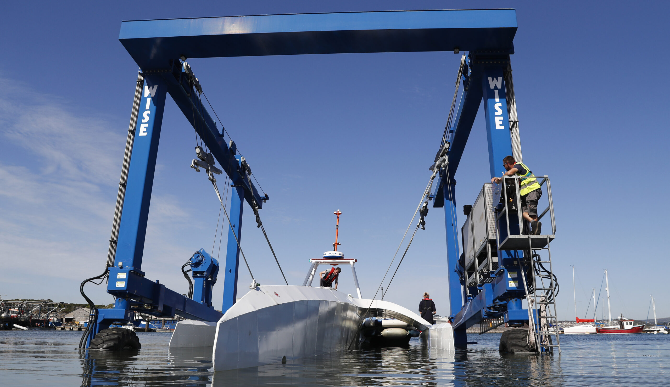 FILE - Technicians lower the Mayflower Autonomous Ship into the water at its launch site on Sept. 14, 2020, for its first outing on water since being built in Turnchapel, Plymouth south west England. The sleek autonomous trimaran docked in Halifax, Nova Scotia on Sunday, June 5, 2022, after more than five weeks crossing the Atlantic Ocean from England, according to tech company IBM, which helped build it. (AP Photo/Alastair Grant, File)