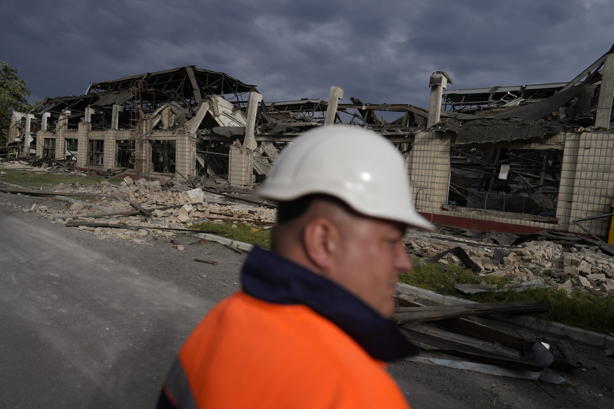 A worker looks at a railway service facility hit by a Russian missile strike in Kyiv, Ukraine, Sunday, June 5, 2022. (AP Photo/Natacha Pisarenko)
