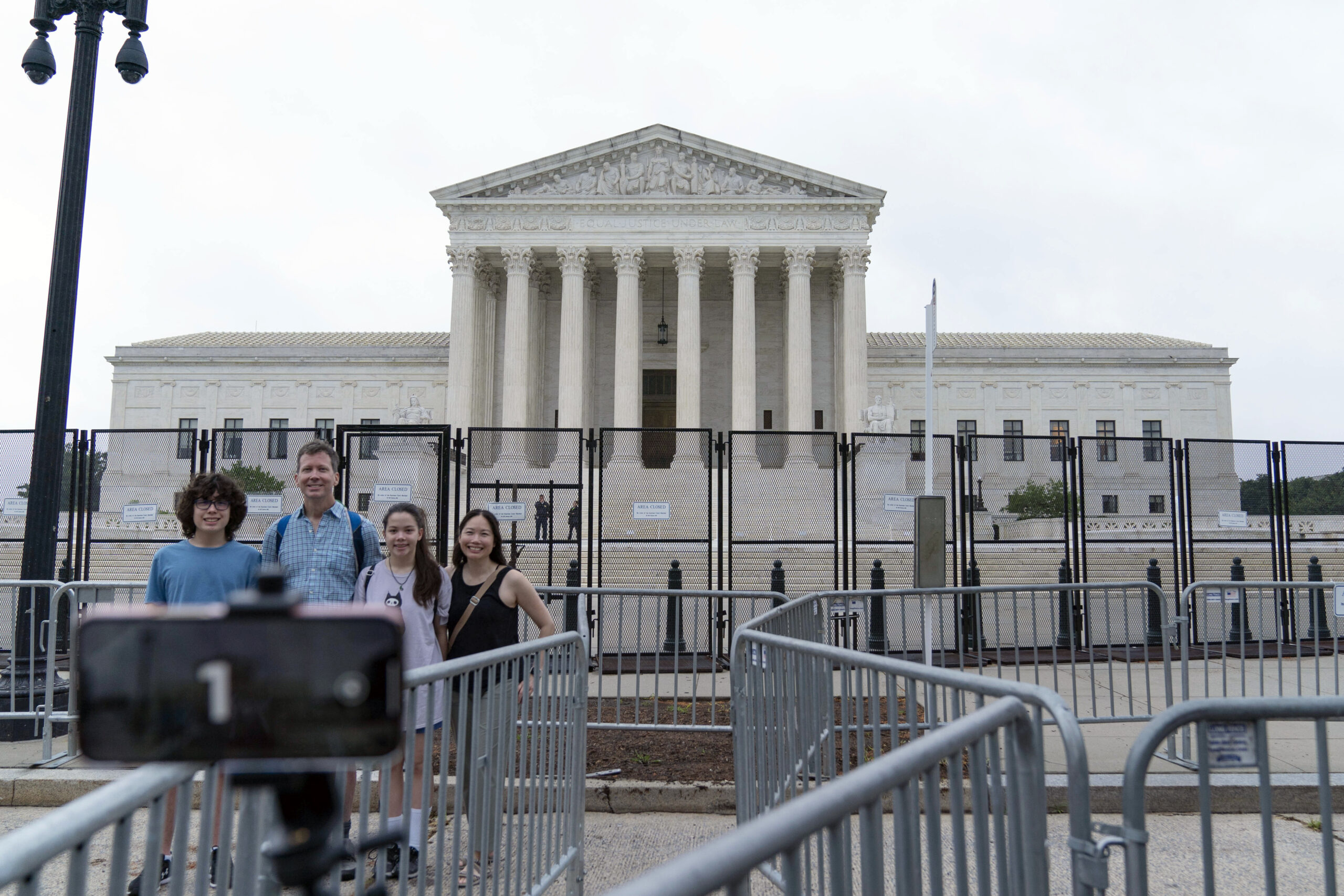 A family takes a selfie outside of the U.S. Supreme Court on Capitol Hill in Washington, Thursday, June 23, 2022. (AP Photo/Jose Luis Magana)