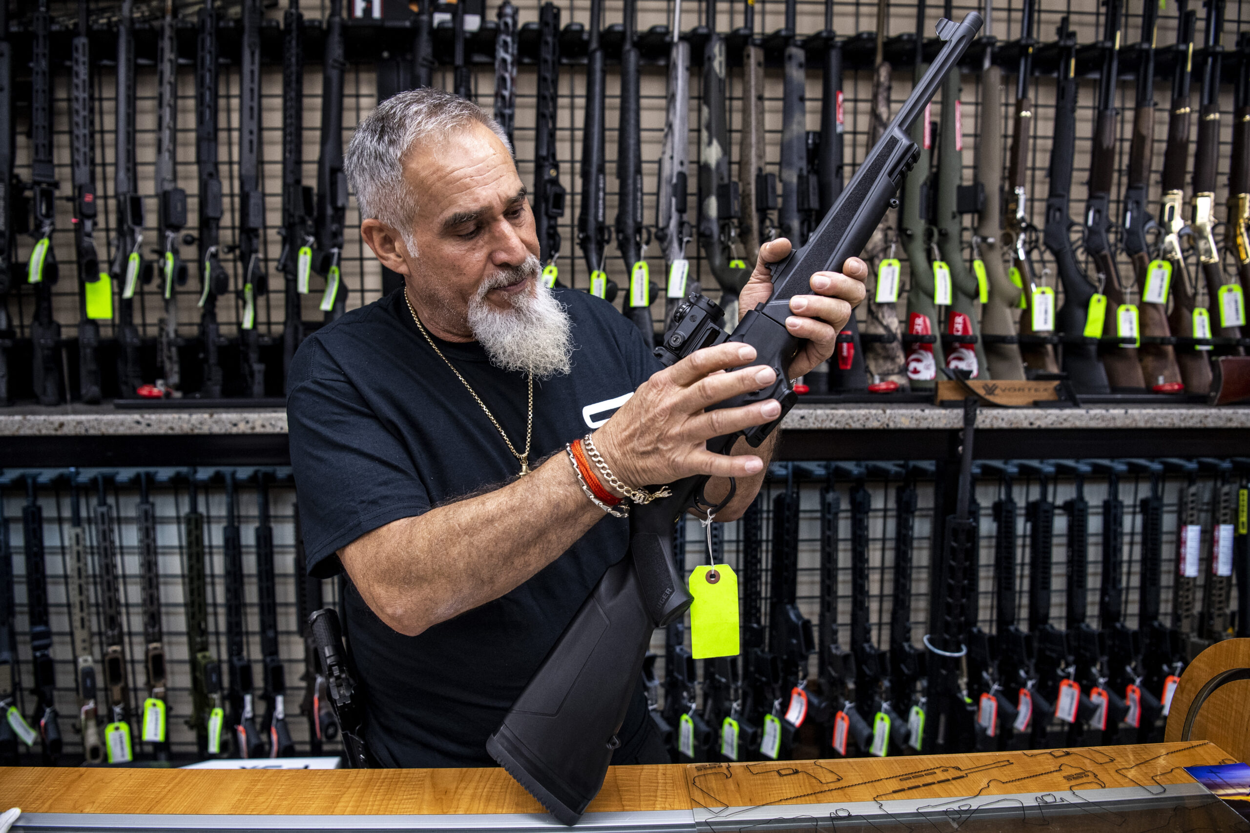 Salesman John Licata demonstrates a competition shooting gun at SP firearms on Thursday, June 23, 2022, in Hempstead, New York. (AP Photo/Brittainy Newman)