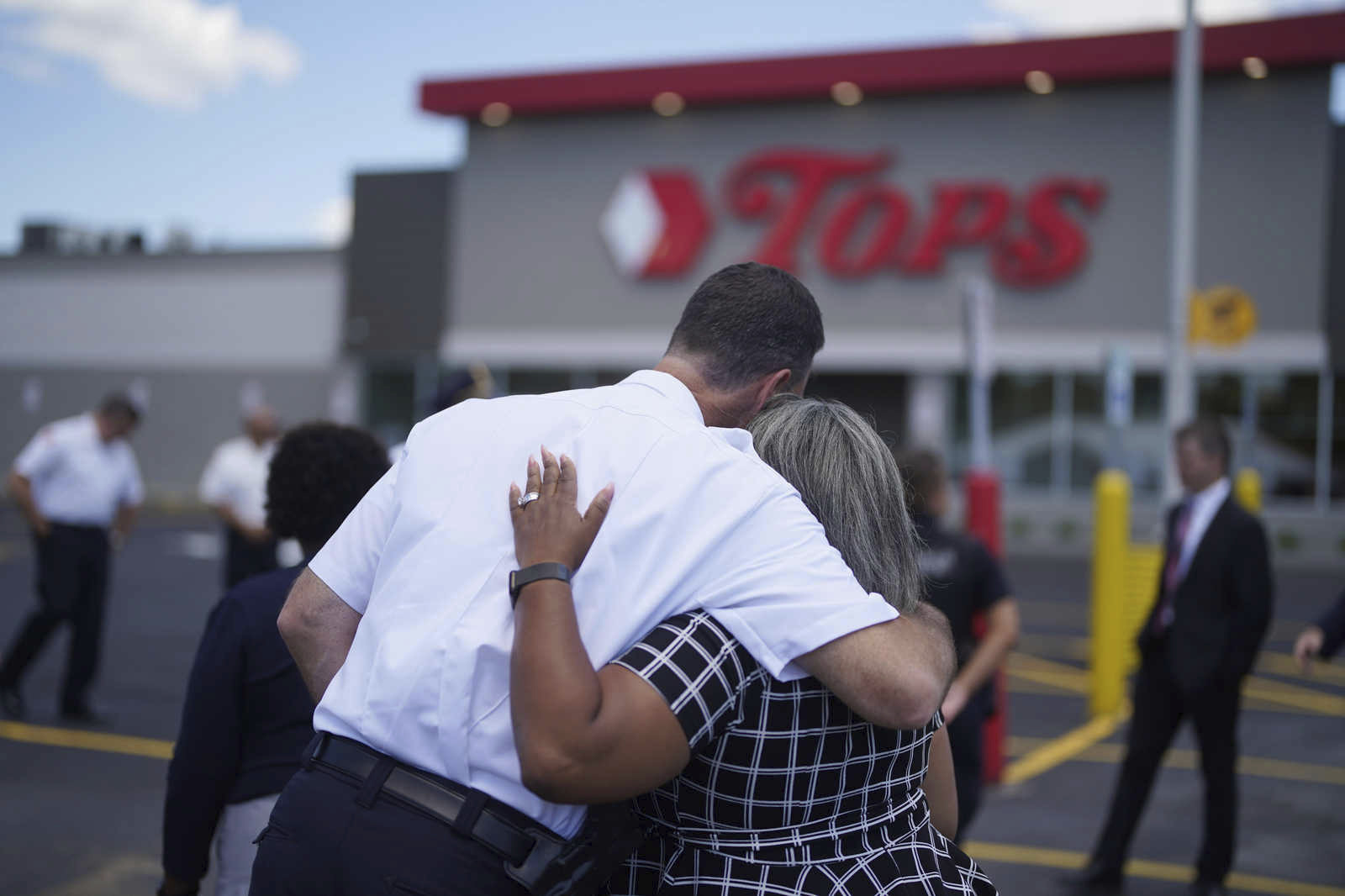 Buffalo Police Commissioner Joseph Gramaglia hugs Leah Holton-Pope, senior advisor to New York Assembly Majority Leader Peoples-Stokes prior to a ceremony to honor the victims on the two-month anniversary of the attack by a racist gunman at a memorial outside the store in Buffalo, N.Y., Thursday, July 14, 2022. (Derek Gee/The Buffalo News via AP)