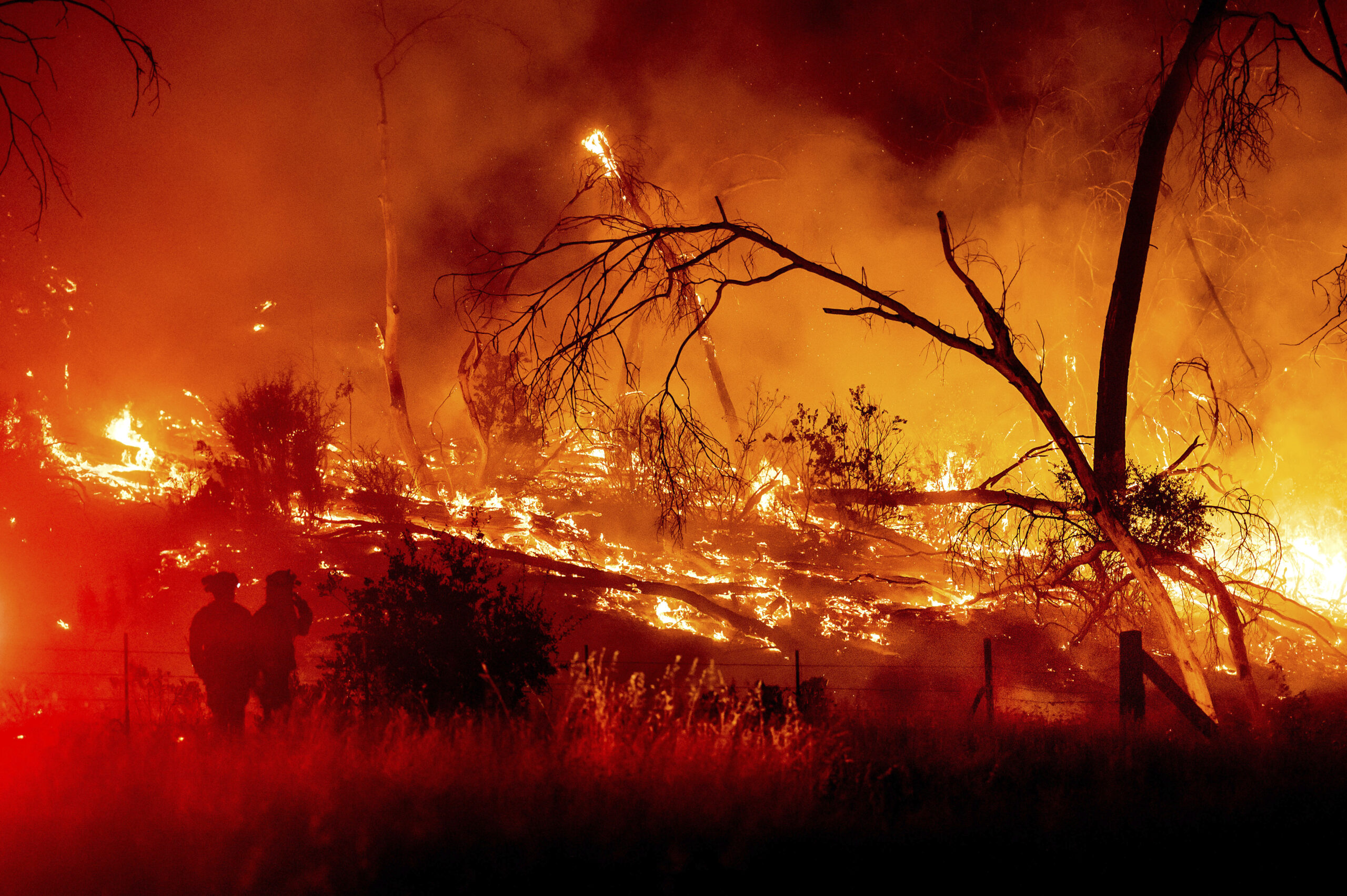 Firefighters battle the Electra Fire in the Rich Gulch community of Calaveras County, Calif., on Monday, July 4, 2022. According to Amador County Sheriff Gary Redman, approximately 100 people sheltered at a Pacific Gas & Electric facility before being evacuated in the evening. (AP Photo/Noah Berger)