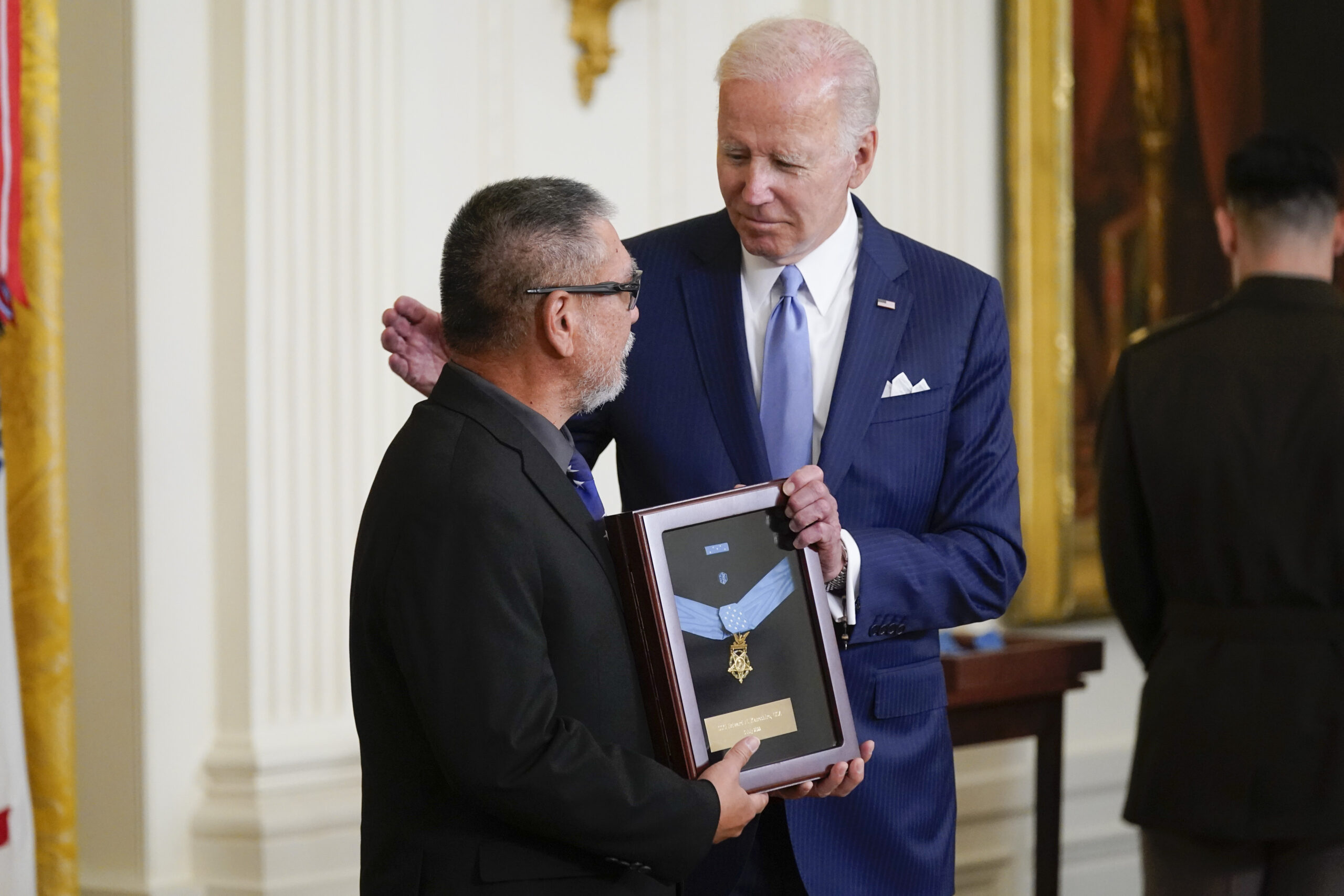 President Joe Biden presents the Medal of Honor to Staff Sgt. Edward Kaneshiro for his actions on Dec. 1, 1966, during the Vietnam War, as his son John Kaneshiro accepts the posthumous recognition during a ceremony in the East Room of the White House, Tuesday, July 5, 2022, in Washington. (AP Photo/Evan Vucci)