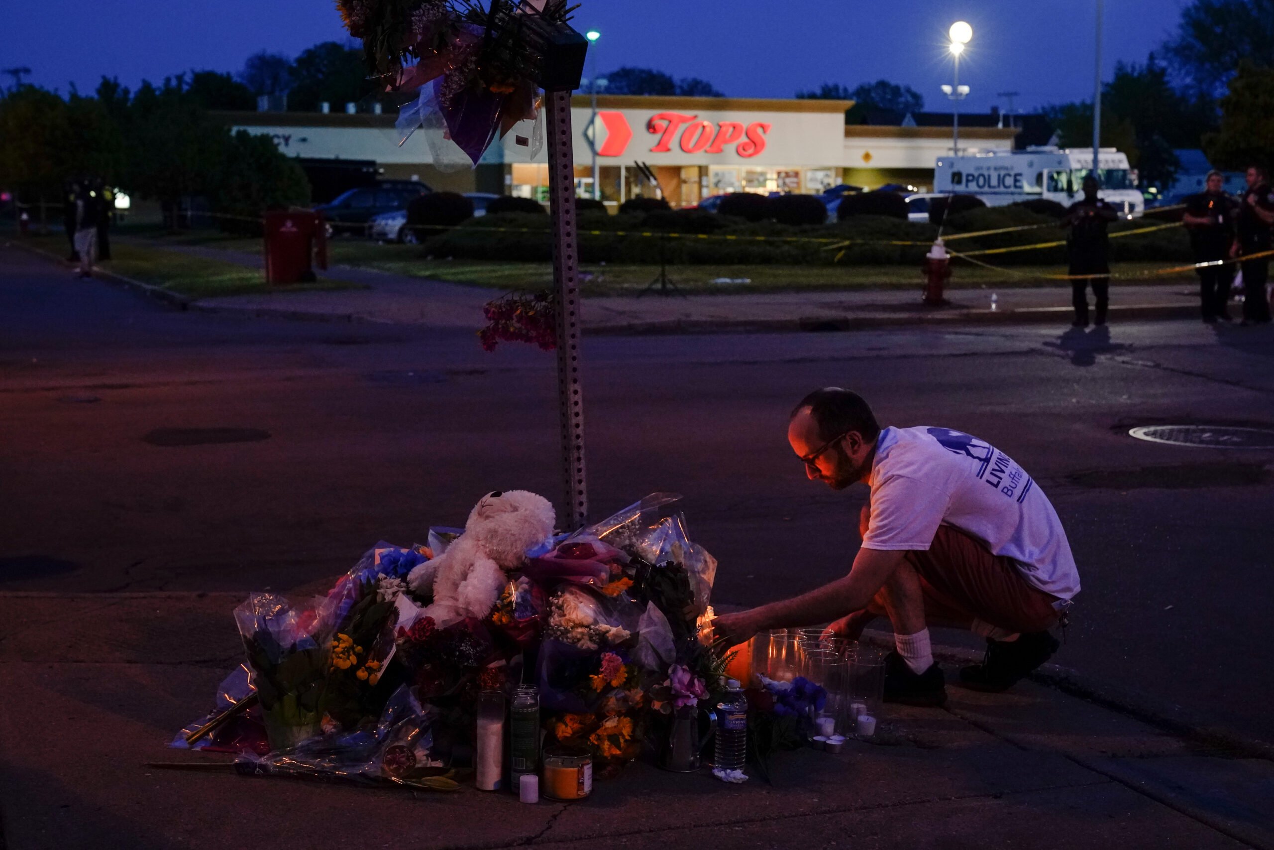 FILE - A person pays his respects outside the scene of a shooting at a supermarket, in Buffalo, N.Y., Sunday, May 15, 2022. The Tops Friendly Markets where 13 people were gunned down by a white gunman is set to reopen its doors Thursday, July 14 two months after the racist attack. (AP Photo/Matt Rourke, File)