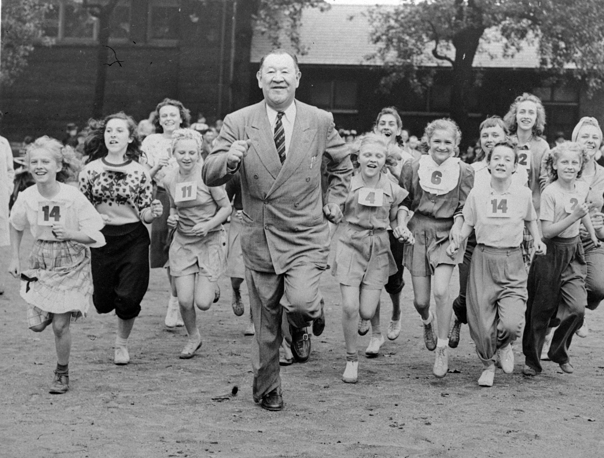 FILE - Big Jim Thorpe, famed American athlete and former U.S. Olympic great, center, sets a fast pace for some girls during a "junior olympics" event on Chicago's south side June 6, 1948 sponsored by a V.F.W. post. Jim Thorpe has been reinstated as the sole winner of the 1912 Olympic pentathlon and decathlon — nearly 110 years after being stripped of those gold medals for violations of strict amateurism rules of the time. The International Olympic Committee confirmed that an announcement was planned later Friday, July 15, 2022. (AP Photo, File)