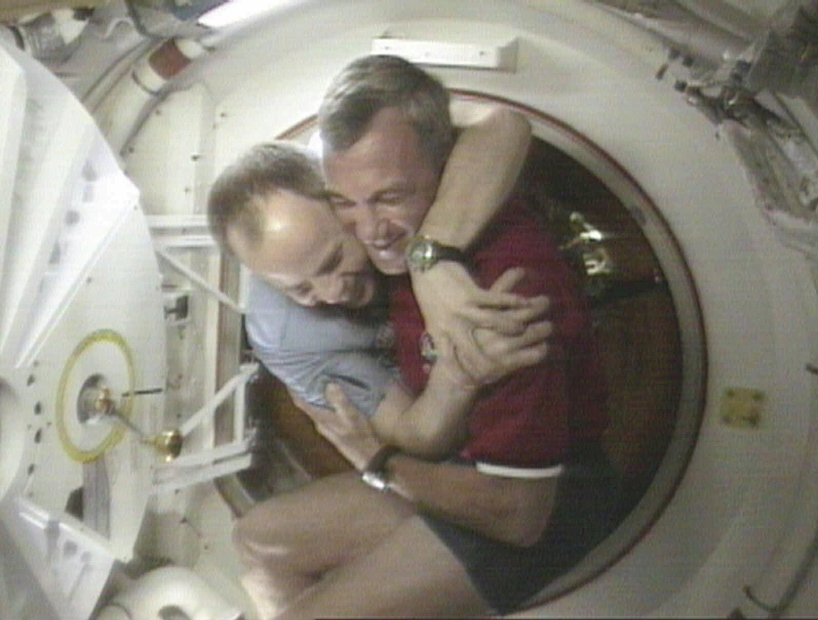 FILE - Shuttle Commander Terrence Wilcutt, right, and Mir Commander Anatoly Solovyev, left, hug after opening the hatches between the space shuttle Endeavour and the Russian Space station Mir Saturday, Jan. 24, 1998 in this image from television. Russia will opt out of the International Space Station after 2024 and focus on building its own orbiting outpost, the country's newly appointed space chief said Tuesday, July 26, 2022. (NASA via AP, File)