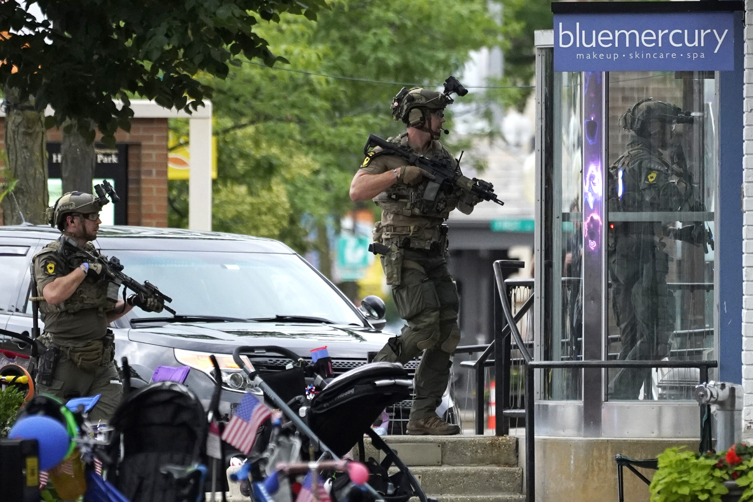 Law enforcement conduct a search after a mass shooting at the Highland Park Fourth of July parade in downtown Highland Park, Ill., a Chicago suburb on Monday, July 4, 2022. (AP Photo/Nam Y. Huh)