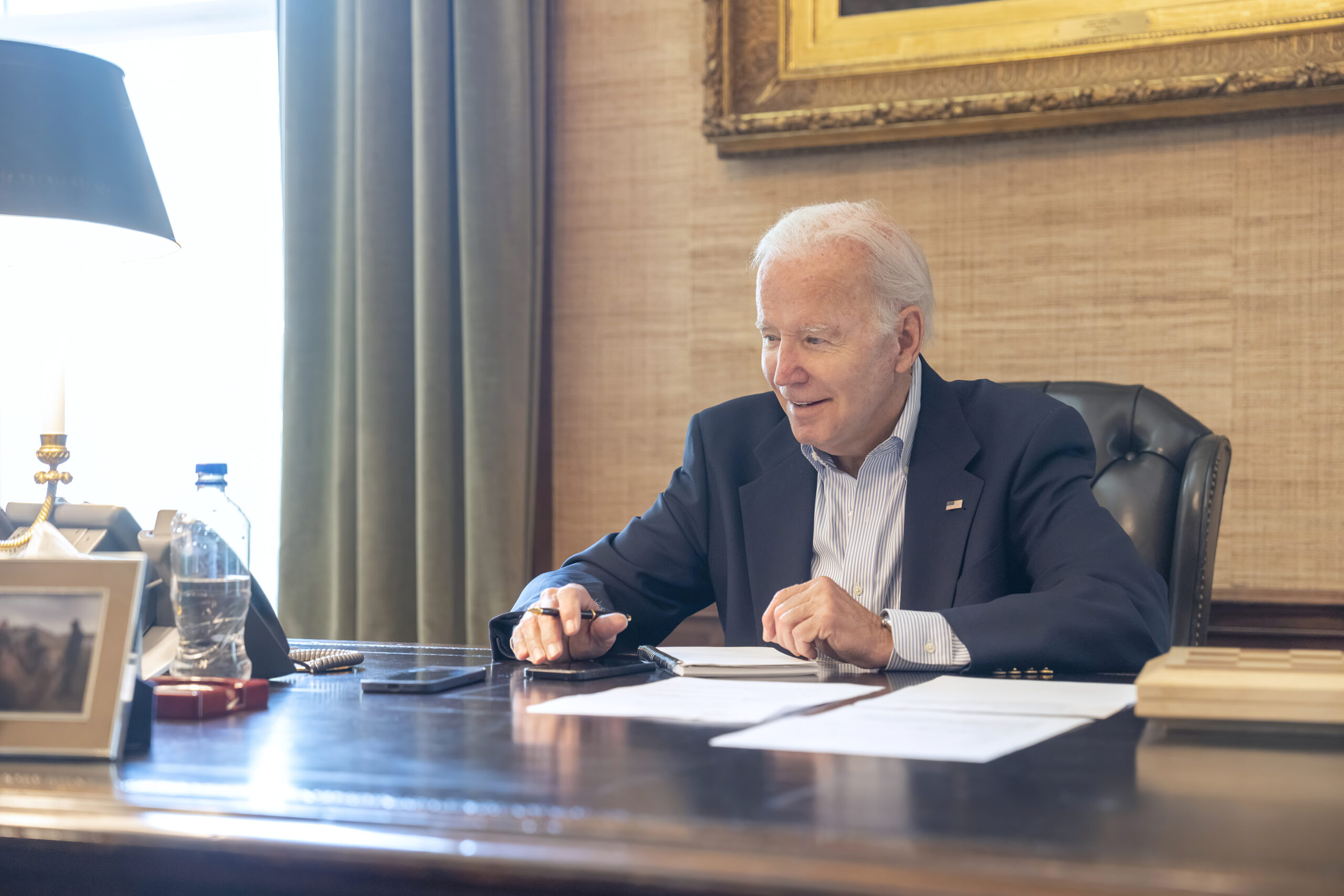 In this image provided by the White House, President Joe Biden speaks with Sen. Bob Casey, D-Pa., on the phone from the Treaty Room in the residence of the White House Thursday, July 21, 2022, in Washington. Biden says he's "doing great" after testing positive for COVID-19. The White House said Biden is experiencing "very mild symptoms," including a stuffy nose, fatigue and cough. He's taking Paxlovid, an antiviral drug designed to reduce the severity of the disease. (Adam Schultz/The White House via AP)