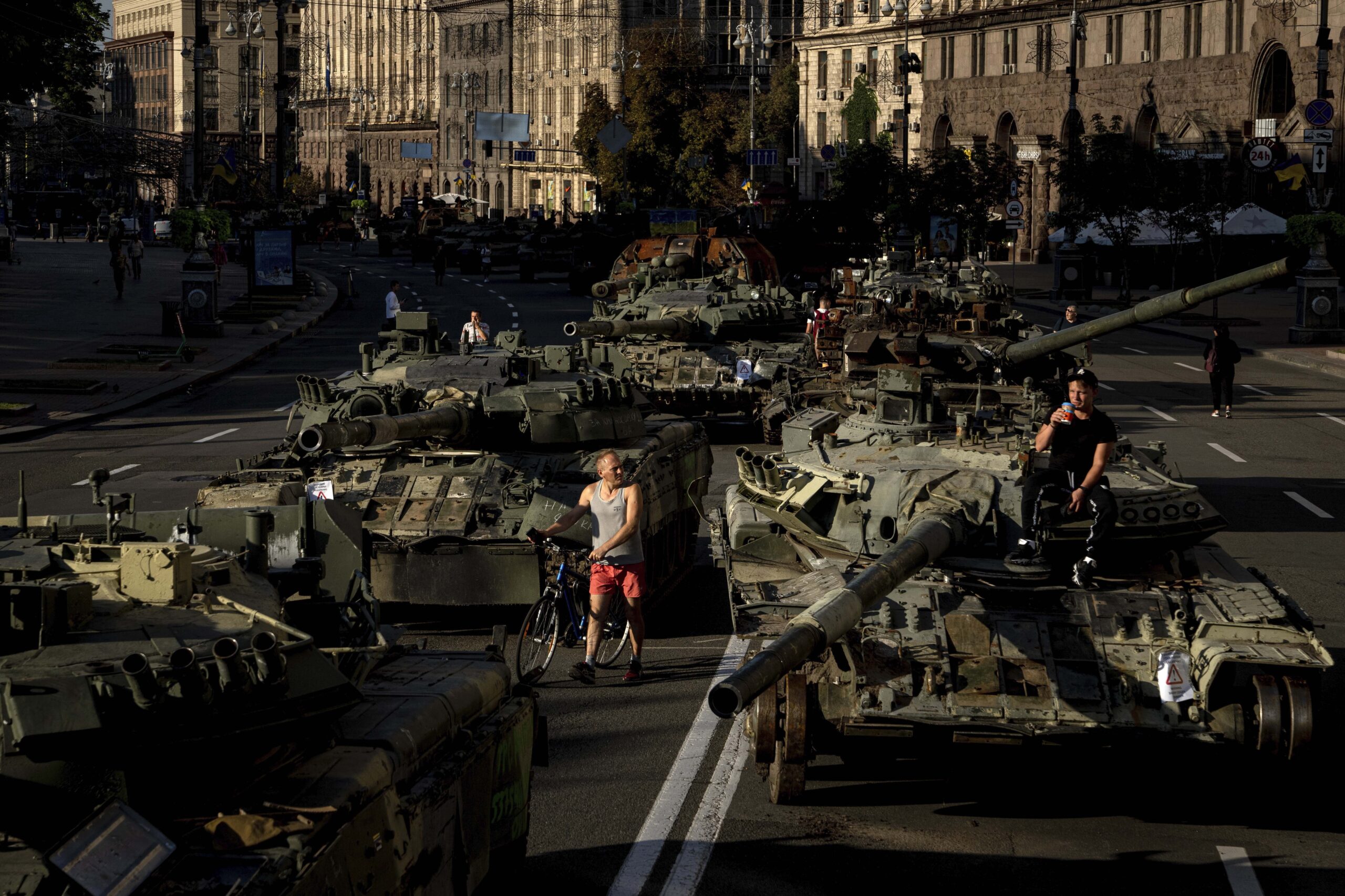 People walk around destroyed Russian military vehicles installed in downtown Kyiv, Ukraine, Wednesday, Aug. 24, 2022. Kyiv authorities have banned mass gatherings in the capital through Thursday for fear of Russian missile attacks. Independence Day, like the six-month mark in the war, falls on Wednesday. (AP Photo/Evgeniy Maloletka)