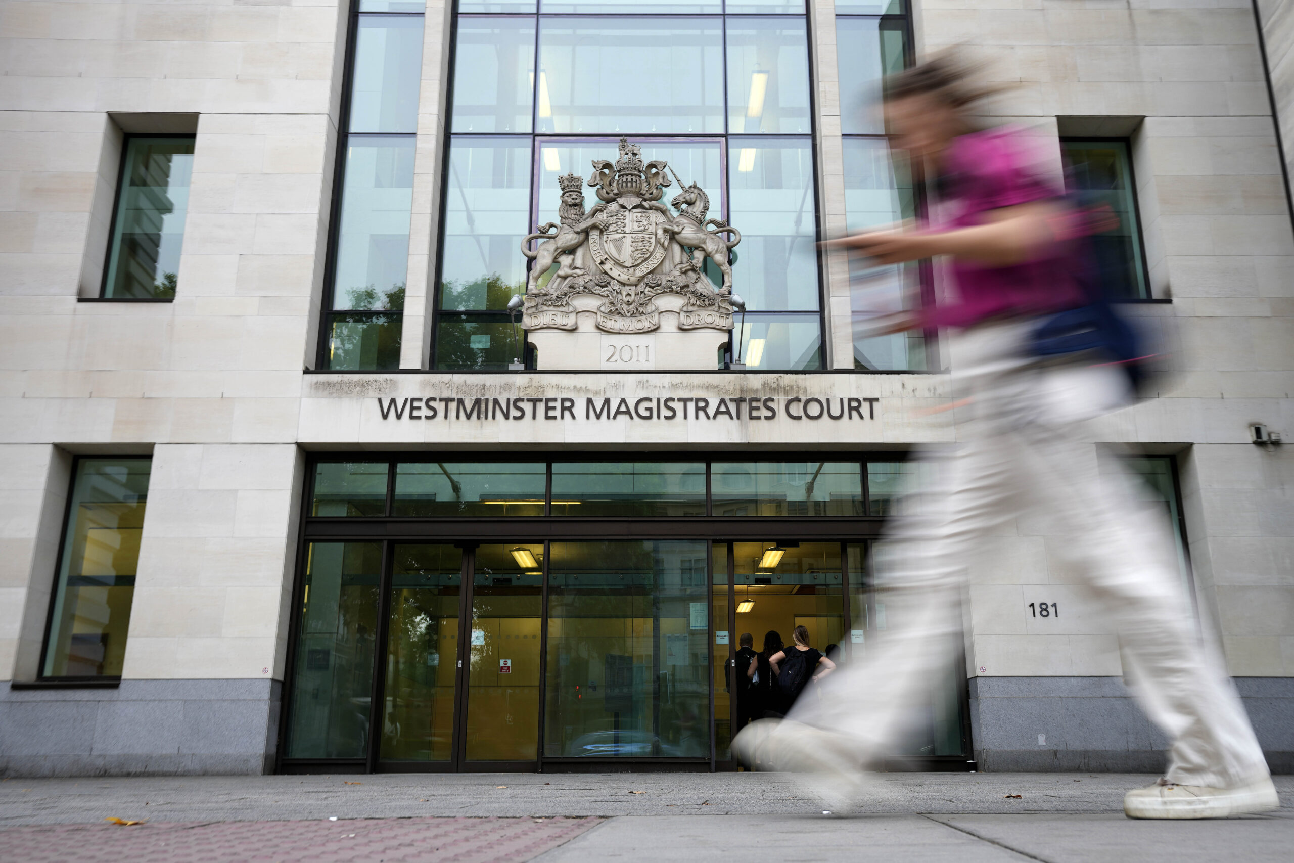 A Woman passes Westminster Magistrates Court in London, Wednesday, Aug. 17, 2022. A 20-year-old man has been charged with intending to injure or alarm The Queen under the Treason Act following an incident on Christmas Day 2021 at Windsor Castle. Jaswant Singh Chail was charged with an offence under section two of the Treason Act 1842 - last used more than 40 years ago - which is 'discharging or aiming firearms, or throwing or using any offensive matter or weapon, with intent to injure or alarm Her Majesty'. (AP Photo/Frank Augstein)