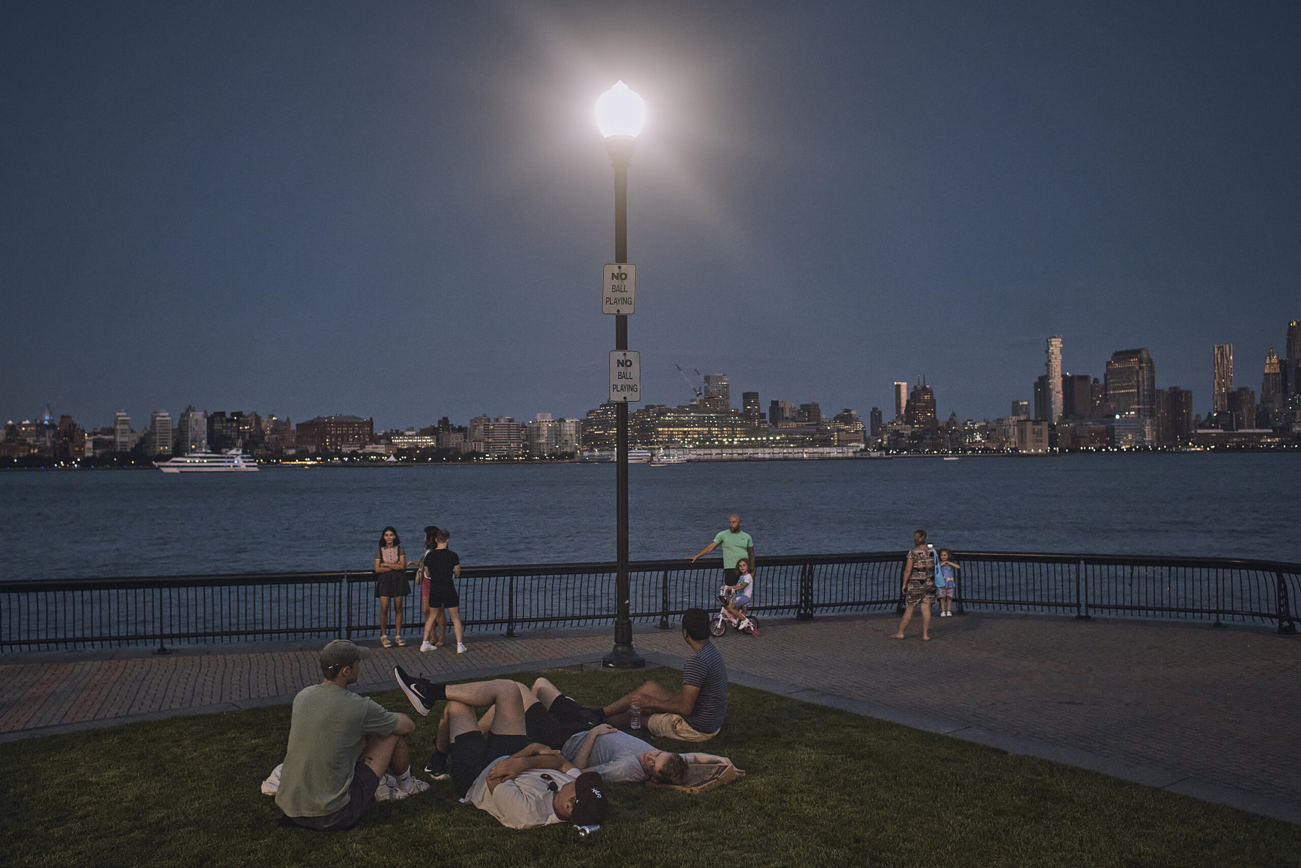 FILE - People spend time at the park at dusk during a summer heat wave, July 21, 2022, in Hoboken, N.J. The continental United States in July set a record for overnight warmth, providing little relief from the day’s sizzling heat for people, animals, plants and the electric grid, meteorologists said. (AP Photo/Andres Kudacki, File)
