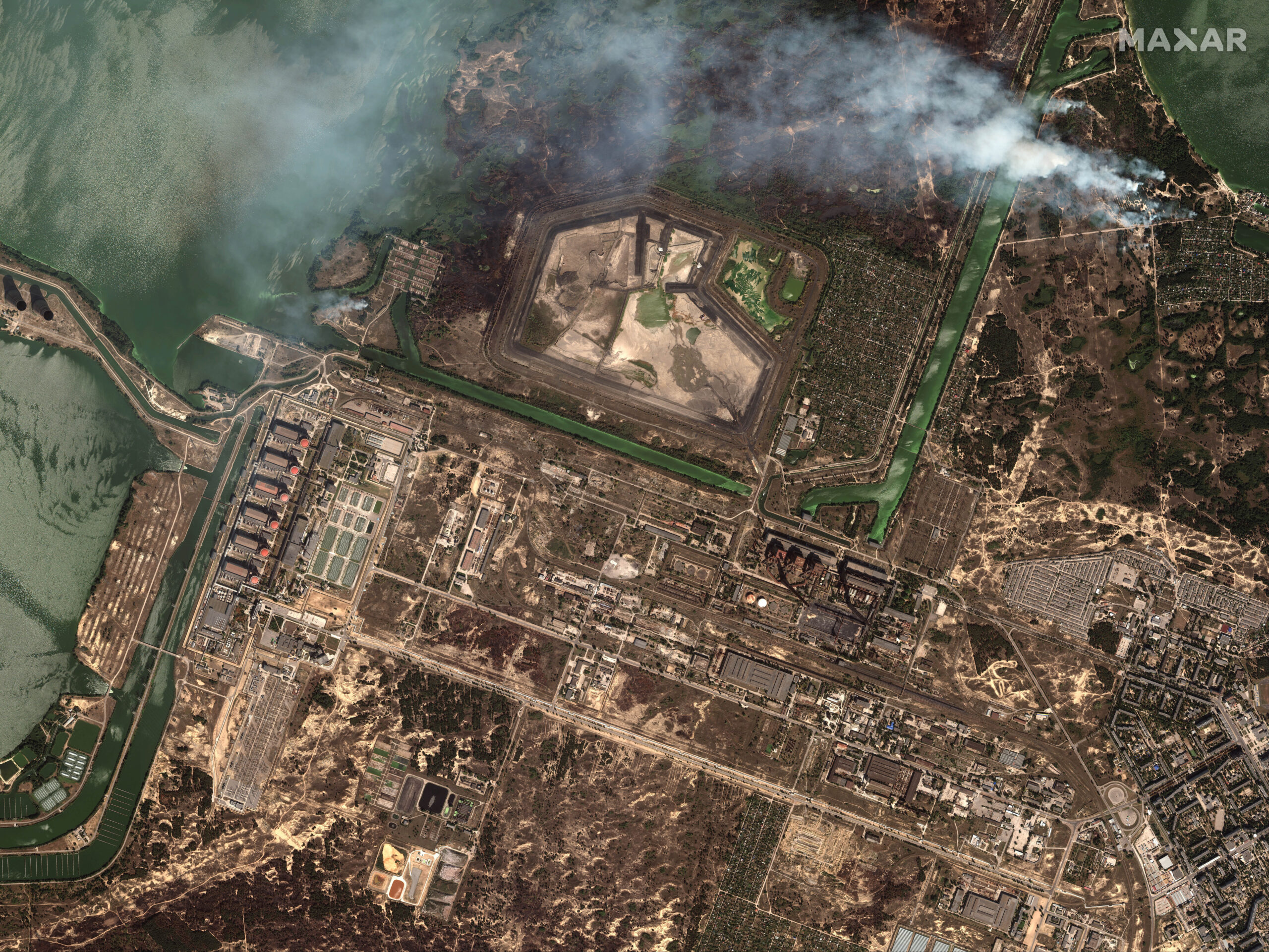 This satellite image provided by Maxar Technologies shows bush fires outside of the main power plant facilities at the Zaporizhzhia nuclear plant in Russian occupied Ukraine, Monday Aug. 29, 2022. A team from the U.N. nuclear watchdog on Monday started its journey to the Zaporizhzhia atomic power plant at the heart of fighting in Ukraine, a long-awaited mission to inspect crucial safety systems that the world hopes will help avoid a catastrophe. (Satellite image ©2022 Maxar Technologies via AP)
