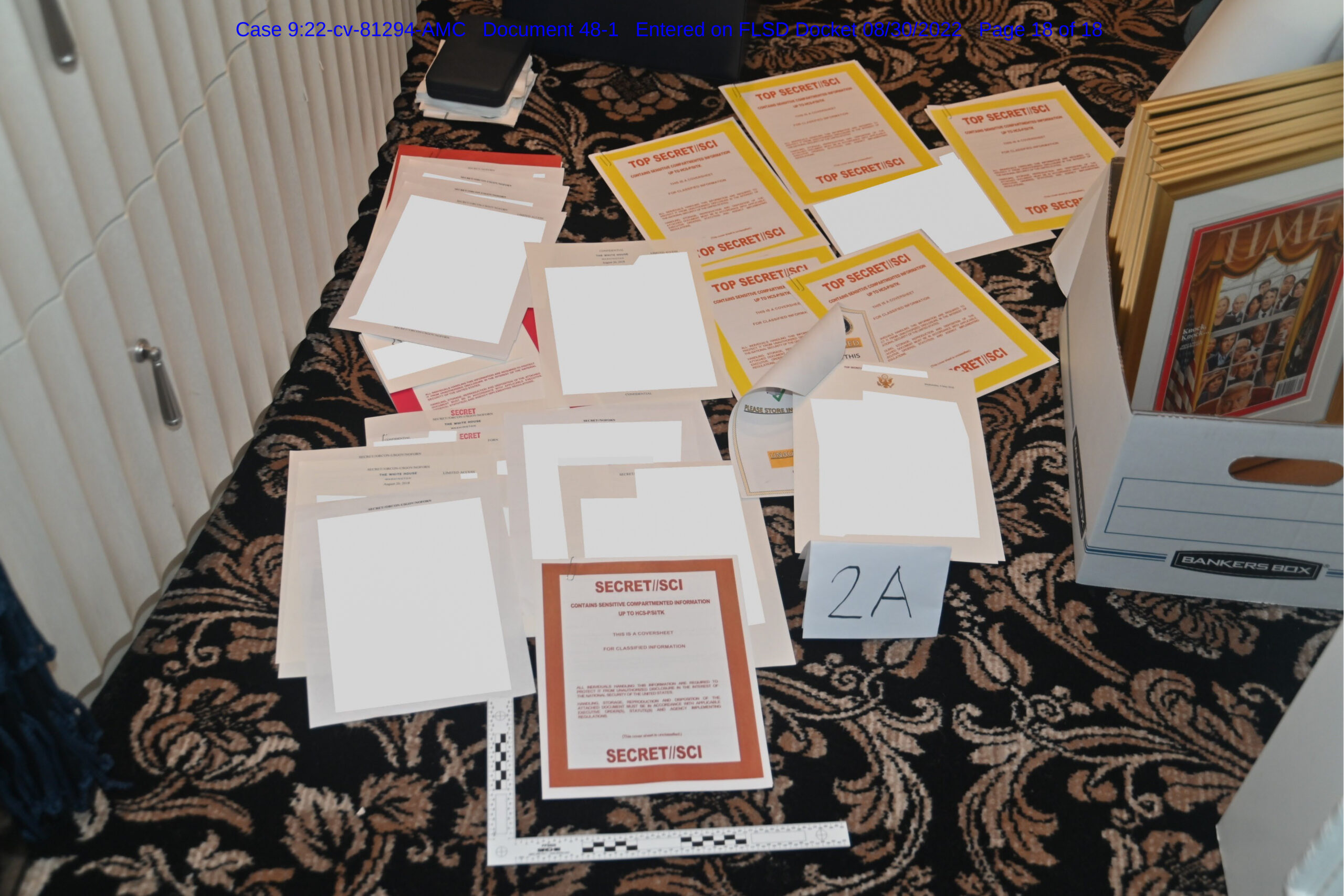 This image contained in a court filing by the Department of Justice on Aug. 30, 2022, and redacted by in part by the FBI, shows a photo of documents seized during the Aug. 8 search by the FBI of former President Donald Trump's Mar-a-Lago estate in Florida. The Justice Department says it has uncovered efforts to obstruct its investigation into the discovery of classified records at former President Donald Trump's Florida estate. (Department of Justice via AP)
