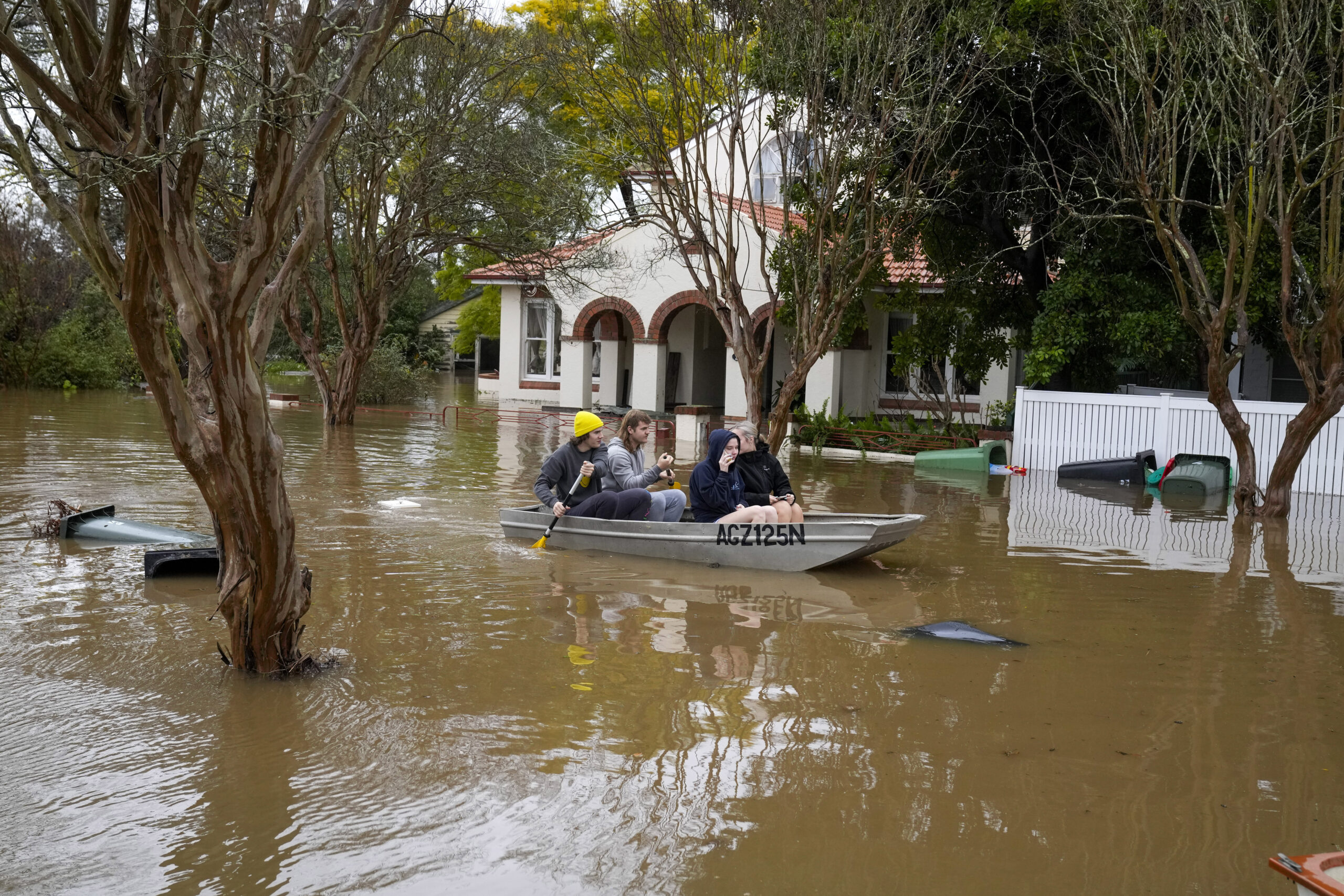 FILE - People paddle through a flooded street at Windsor on the outskirts of Sydney, Australia, July 5, 2022. The U.N. weather agency is predicting the phenomenon known as La Nina is poised to last through the end of this year, a mysterious “triple dip” — the first this century — caused by three straight years of its effect on climate patterns like drought and flooding worldwide. (AP Photo/Mark Baker, File)