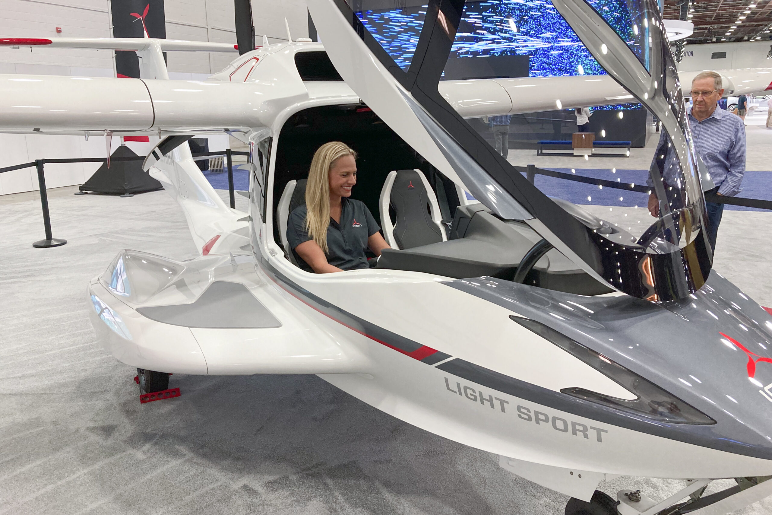 Suzanne Clavette, ICON Aircraft's marketing manager and a pilot, sits in an ICON A5 aircraft on the floor of the North American International Auto Show in Detroit, on Monday, Sept. 19, 2022. ICON Aircraft is one of the companies displaying their flying vehicles at NAIAS as part of the show's Air Mobility Experience segment. (AP Photo/Mike Householder)