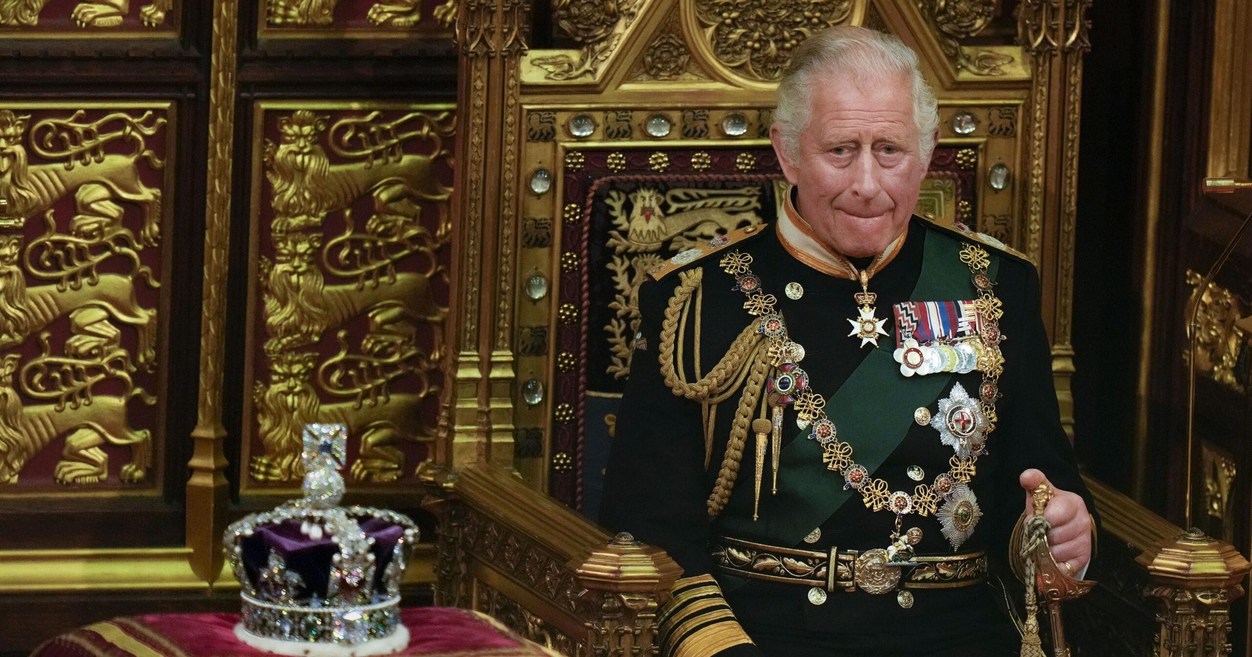 FILE - Prince Charles is seated next to the Queen's crown during the State Opening of Parliament, at the Palace of Westminster in London, May 10, 2022. Queen Elizabeth II did not attend the opening of Parliament amid ongoing mobility issues. Prince Charles has been preparing for the crown his entire life. Now, that moment has finally arrived. Charles, the oldest person to ever assume the British throne, became king on Thursday Sept. 8, 2022, following the death of his mother, Queen Elizabeth II. (AP Photo/Alastair Grant, Pool, File)