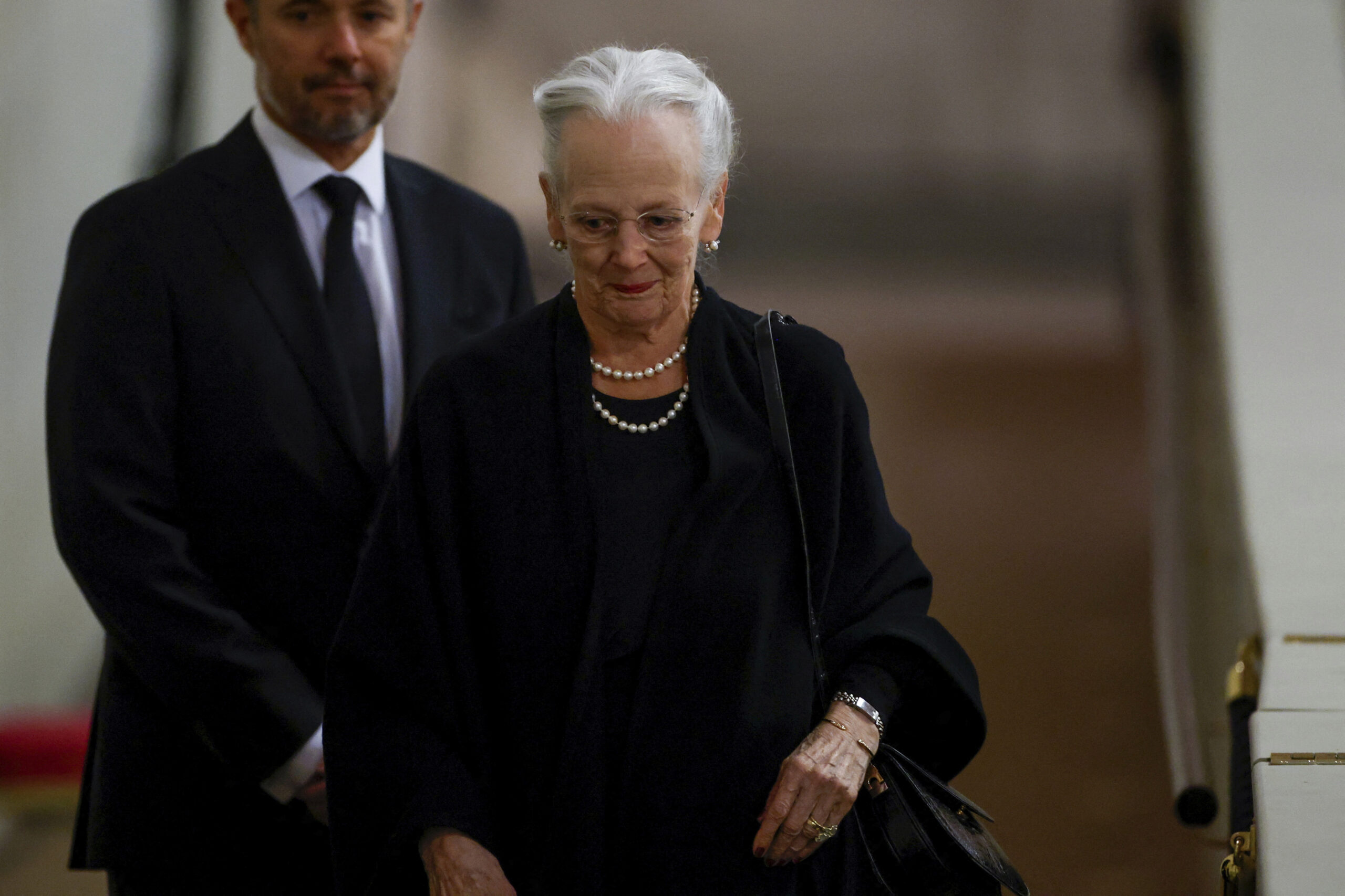 FILE - Denmark's Queen Margrethe pays her respect to the coffin of Britain's Queen Elizabeth, following her death, during her lying-in-state at Westminster Hall, in London, Sunday Sept. 18, 2022. Denmark’s Queen Margrethe II has tested positive for the coronavirus after attending the funeral of Britain’s Queen Elizabeth II. The Danish royal palace said Wednesday, Sept. 21, 2022 that the 82-year-old Margrethe canceled her official duties after the Tuesday night test. she previously tested positive for the virus in February. (John Sibley/Pool via AP, File)